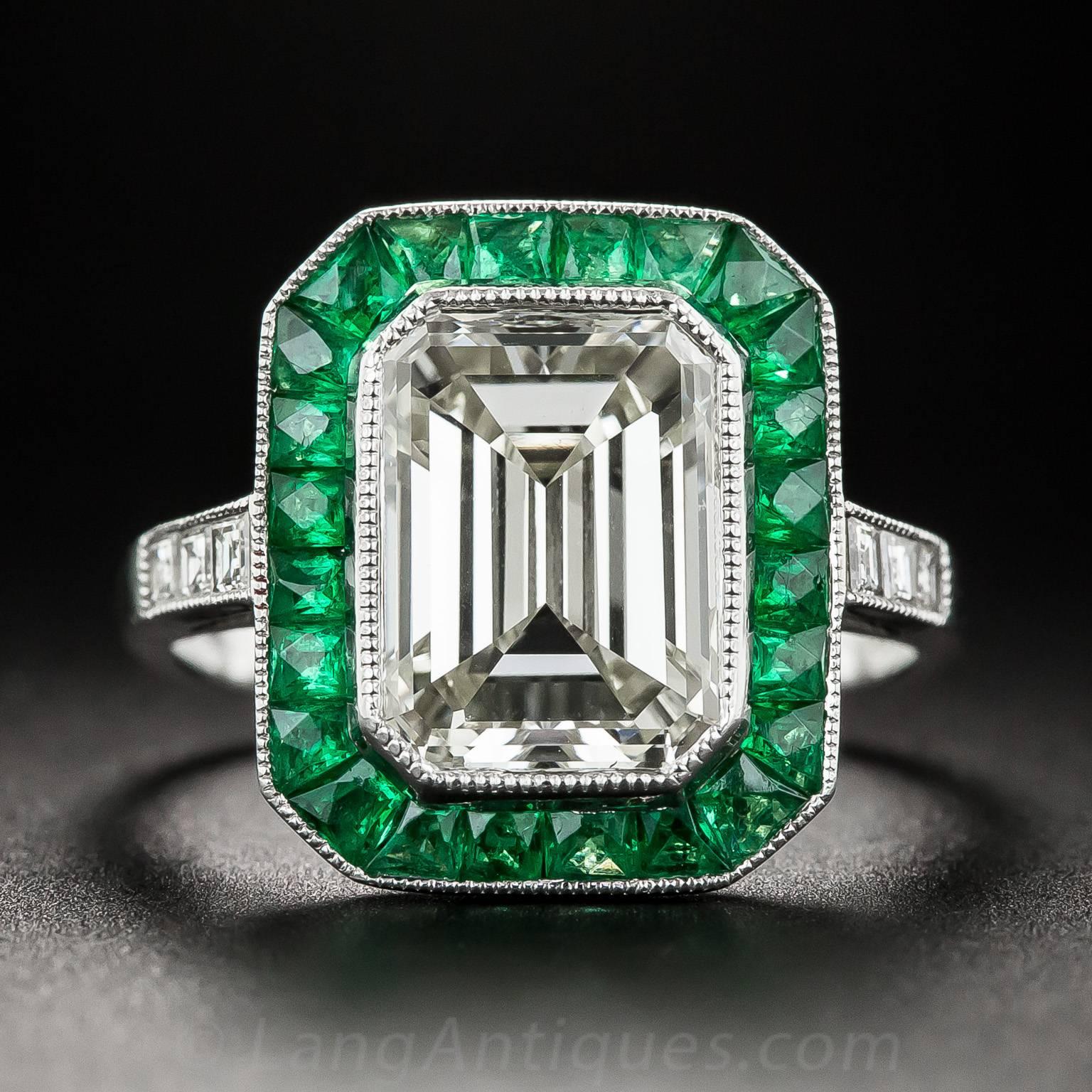 A truly stunning and sensational new Art Deco style engagement ring, finely hand-fabricated in in platinum, starring a bright and shining emerald-cut diamond weighing 3.00 carat. The gorgeous stone is dramatically framed by vibrant green faceted