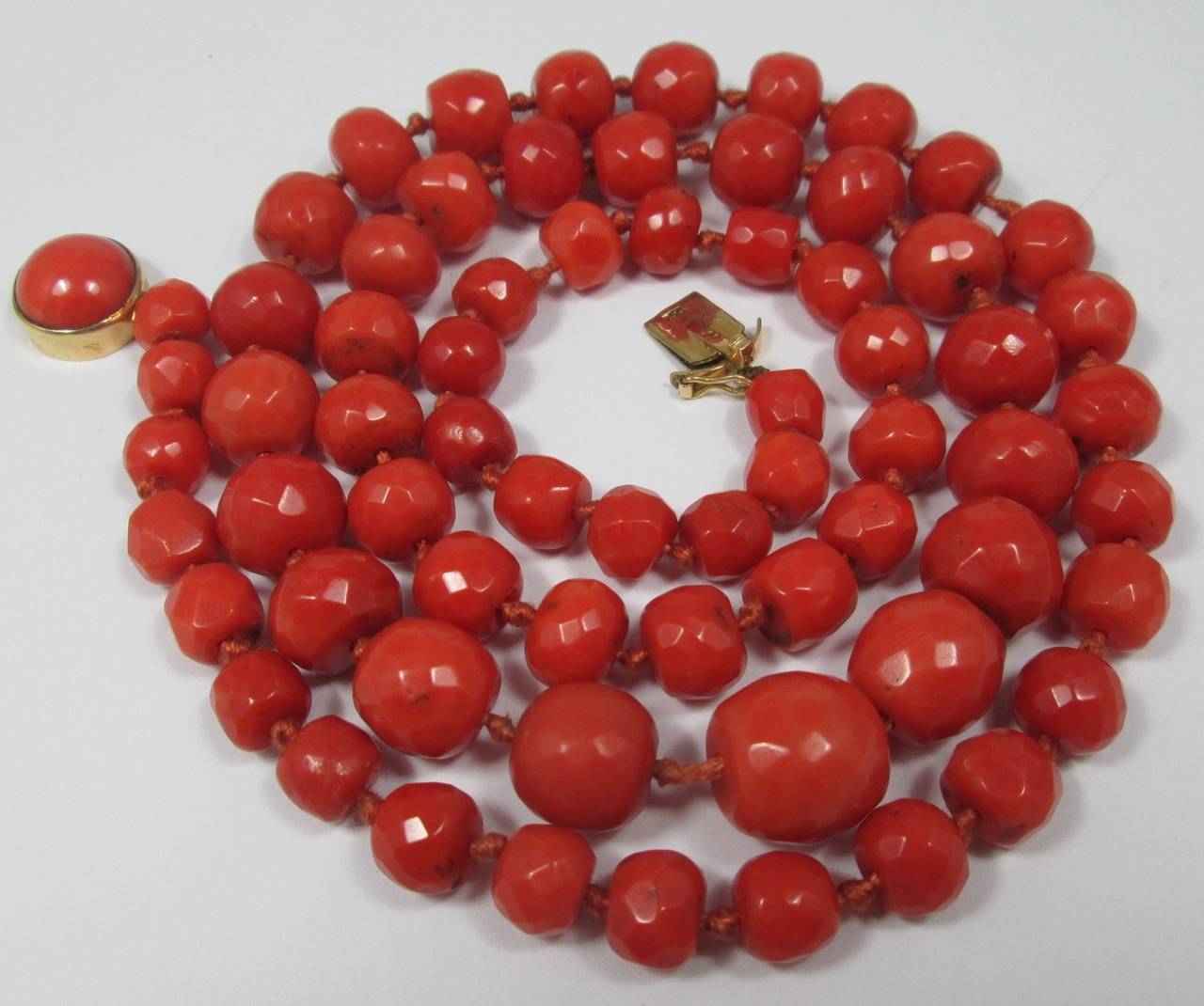 Comprising 67 bouton-shaped faceted beads mesuring approx. from 6 to 11. 5mm diameter, to a round cabochon coral set 18kt yellow gold clasp

63 cm long 

Weight 58.9 gr.