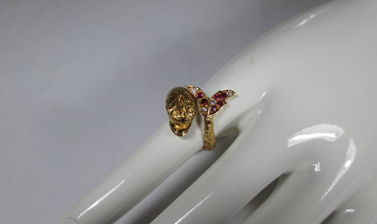 Designed as a dolphin with round cut rubies eyes and rubies and diamond set bifurcated tail. 

Mounted 18Kt chased yellow gold

Finger size: 5 1/2

Weight: 11.5  gr

PLEASE NOTE: OUR PRICE IS FULLY INCLUSIVE OF SHIPPING, IMPORTATION TAXES &