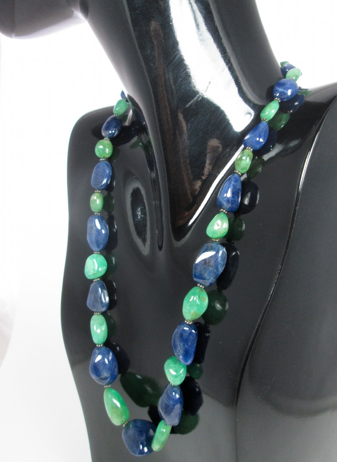 A single strand necklace consisting of graduated eighteen polished emerald and seventeen sapphire beads measuring from approximately 8 mm to 25mm, completed by a 18Kt white and diamond gold clasp
Length 63 cm