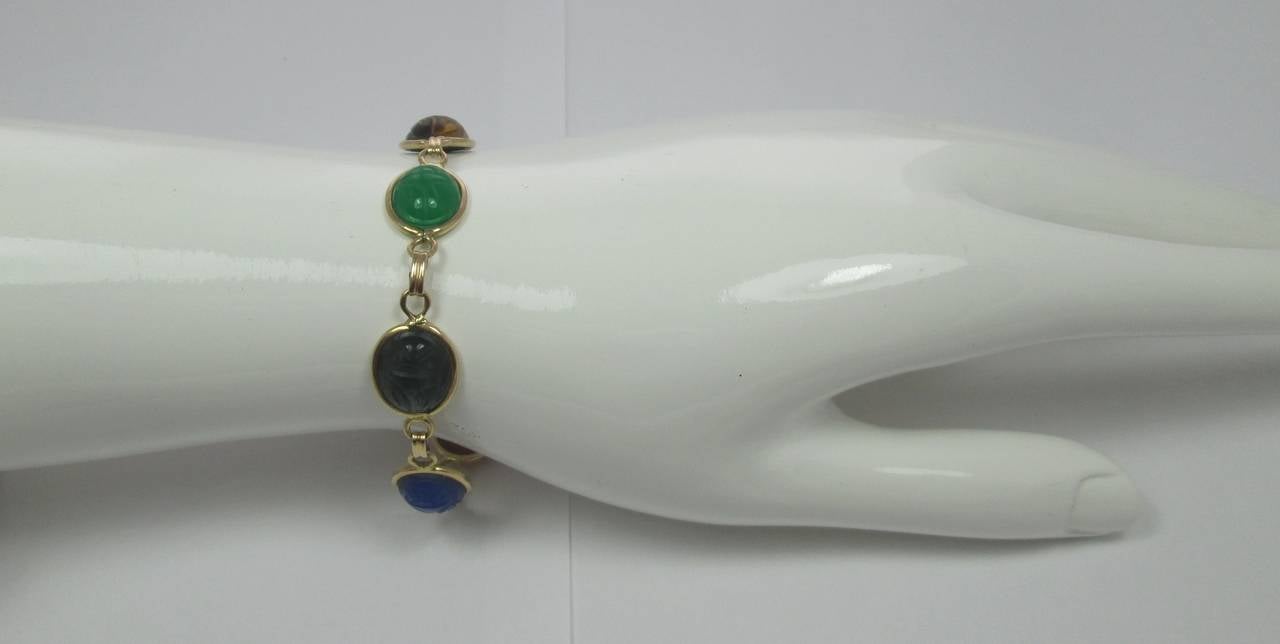 Designed as a line of carved semi-precious stones scarabs

Mounted in 18Kt yellow gold

18.5 cm long