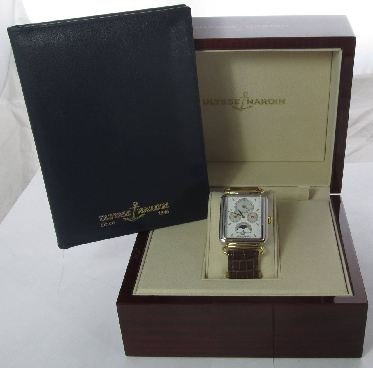 No. 6355, Ref. 164-44.   

Very fine, rectangular, water-resistant, stainless steel and yellow gold wristwatch with triple-date calendar and moon phases. 

With circular gilt-finished lever movement, 19 jewels, gilt rotor, the white dial with