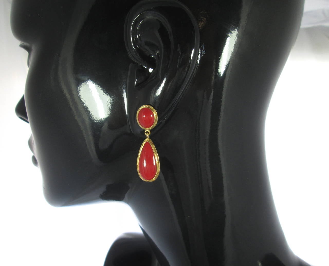 Each designed with an oval gold top centering an oval smooth cabochon coral approx. 10 mm high, suspending a pear shaped gold element containing a drop shaped coral approx. 20 mm long.
Posts and butterfly friction backs for pierced ears
Mounted in