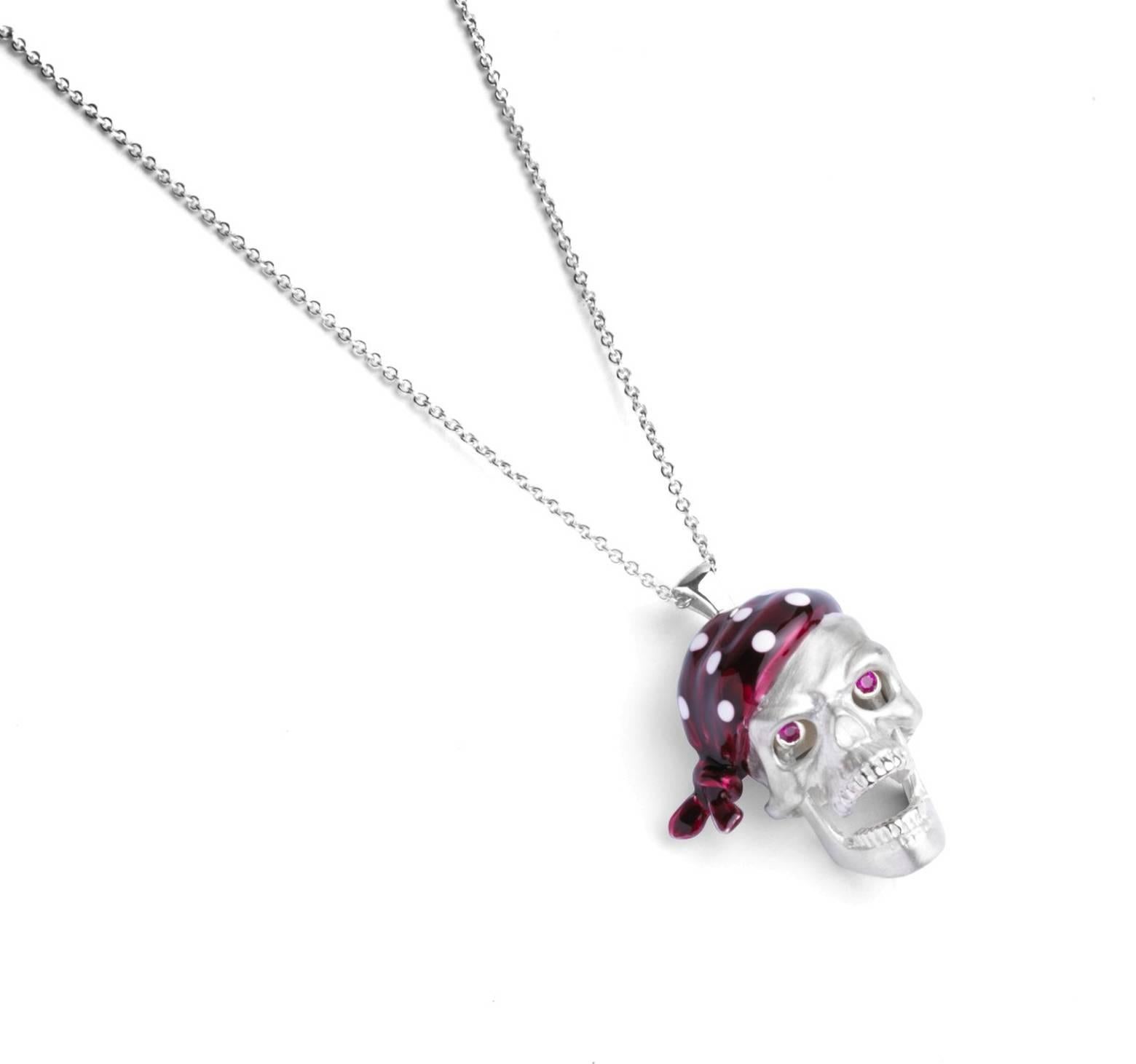 
The sterling silver pirate skull pendant has a n opening jaw and popping ruby eyes. With a red enamel bandana it is fitted on to a 15