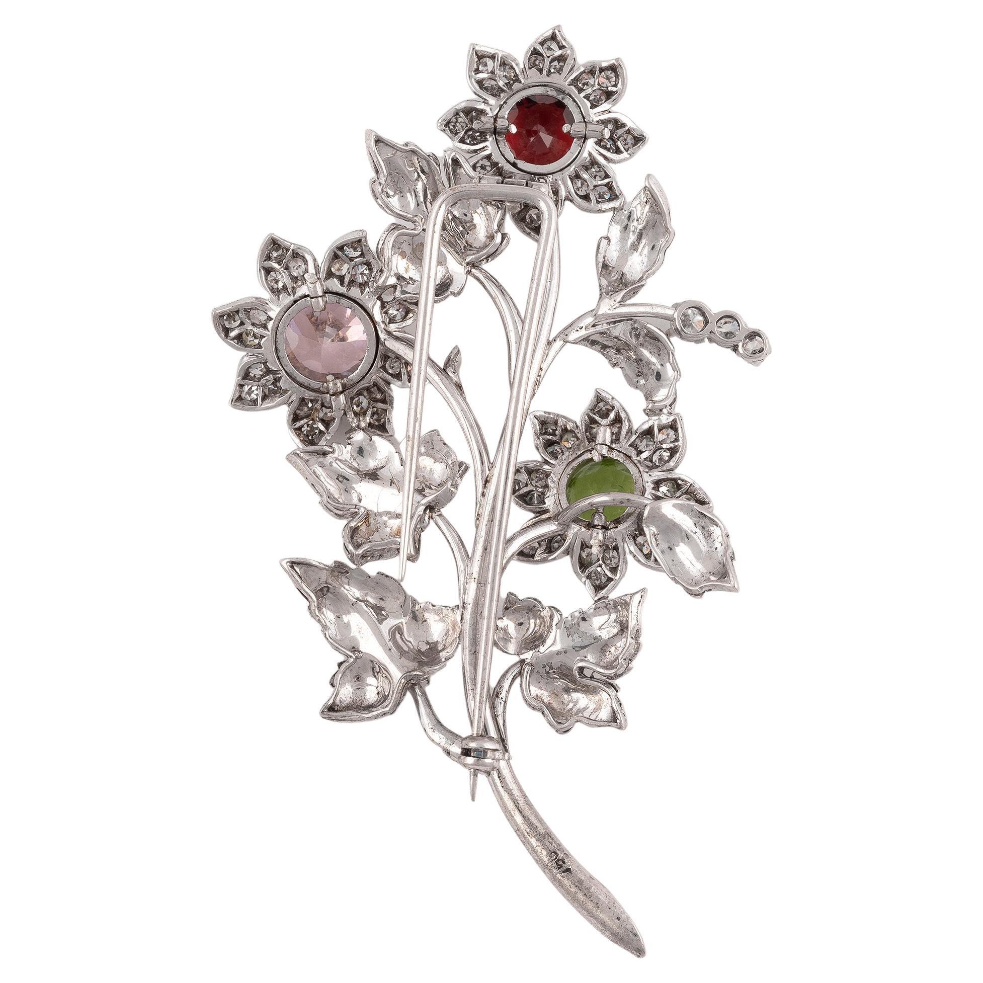 

Of bouquet motif, each yellow gold flower head centered by a rubellite, peridot and pink quartz, framed by petals pavé-set with round brilliant-cut diamonds, the white gold stems accented by bi-color gold leaves, set with round brilliant-cut