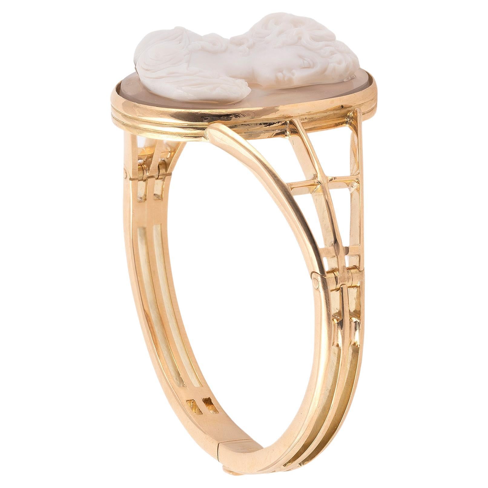 

Le camée ovale sculpté en agate blanche et noire représente une jeune fille de trois quarts profil, avec de fins détails sur les cheveux flottants, les bijoux et la robe de style Empire, serti en or jaune 18 carats, bracelet à charnière,