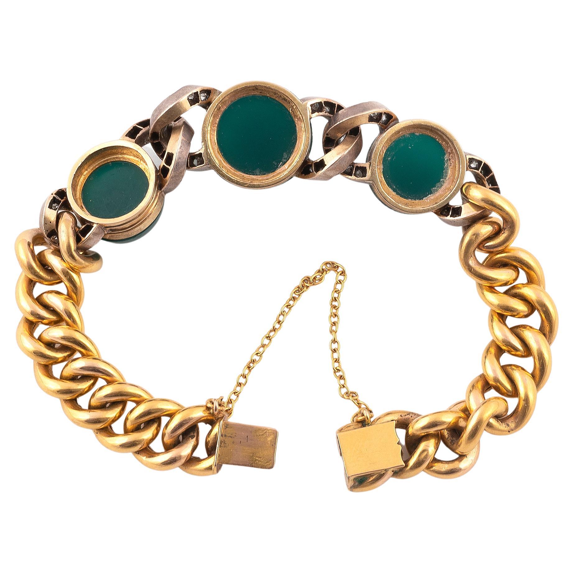 
Bracelet adorned with a curb link retaining three cabochons of green agate surrounded by links paved with rose-cut diamonds. Frame in yellow gold and silver. Safety at the clasp. French assaymarks, workshop mark . Wrist circumference: 17