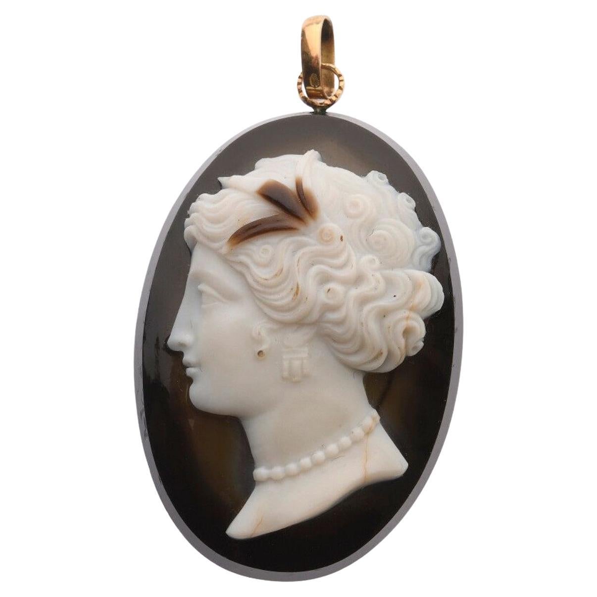 


CAMEO on multilayer agate with the profile of a young woman, her hair richly chiseled and adorned with pearls and earrings. The bail in yellow gold 750 / °°. Period end of the 19th century. 4.4 x 3 cm. Gross weight: 18.8 g 