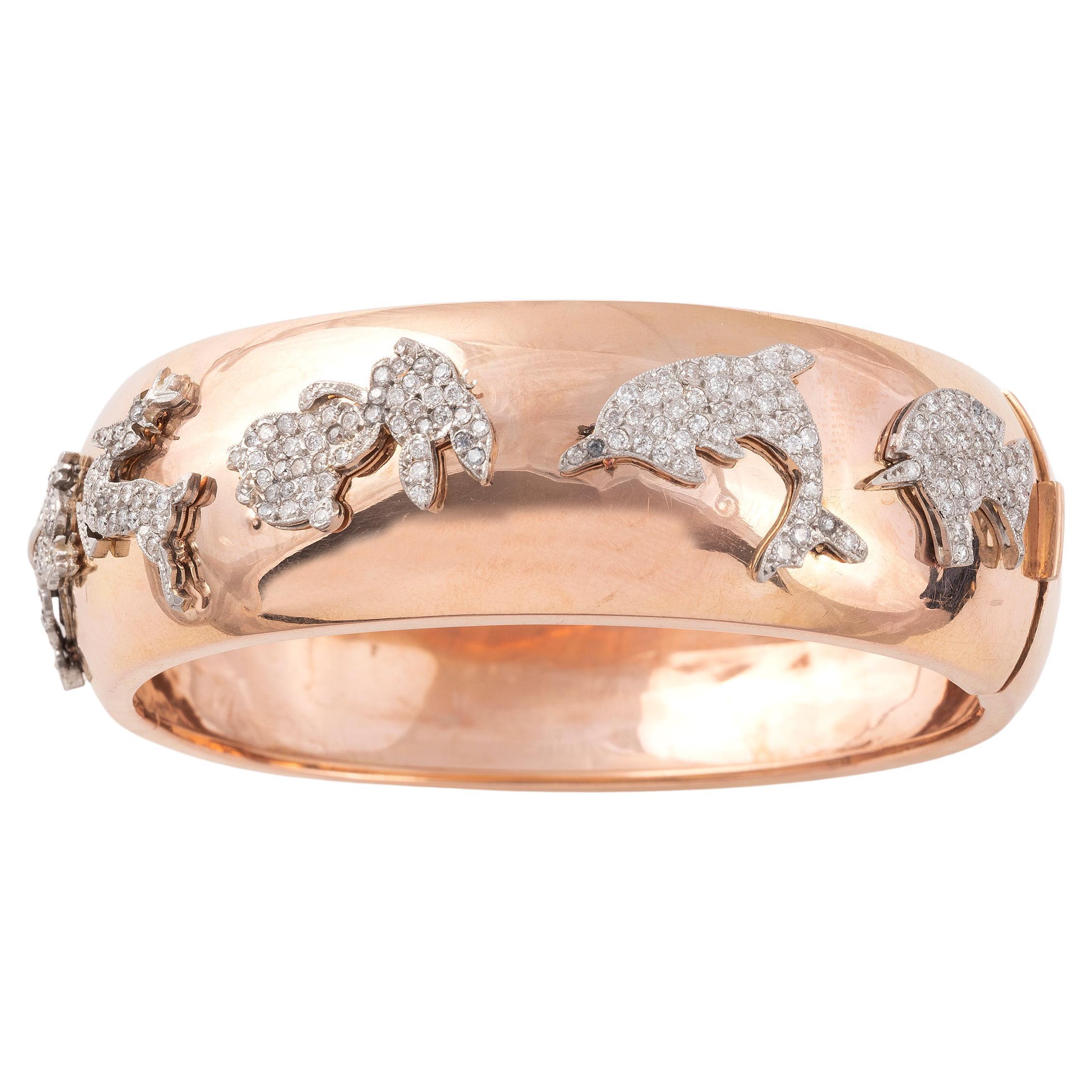 The wide, gold bangle bracelet top featuring five platinum art deco charms, in the animal form, size: 6 3/4in
Wide :22mm
Weight: 28.5gr.
