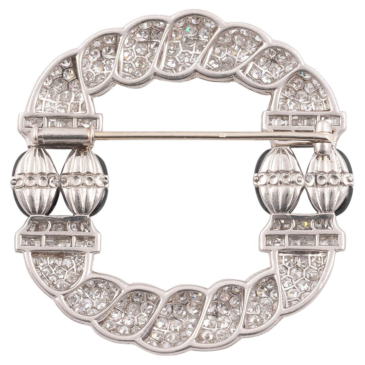The large-cable pattern is paved with old brilliant-cut diamonds and rows of square diamonds. In the center four sapphire olives with gadroons and surrounded by small rose-cut diamonds. Platinum setting (18K white gold pin). Gross weight: 19.32 gr.