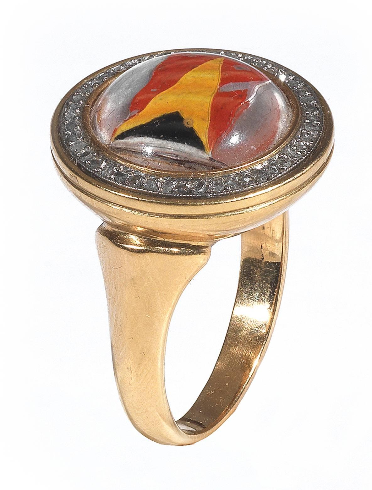 With a domed round rock crystal reverse intaglio painted to depict three colors Navy flag

To a rose-cut diamond frame mounted in silver and 18Kt Gold.

Weight: 9.8 gr

English, 1890 ca

Size 7
