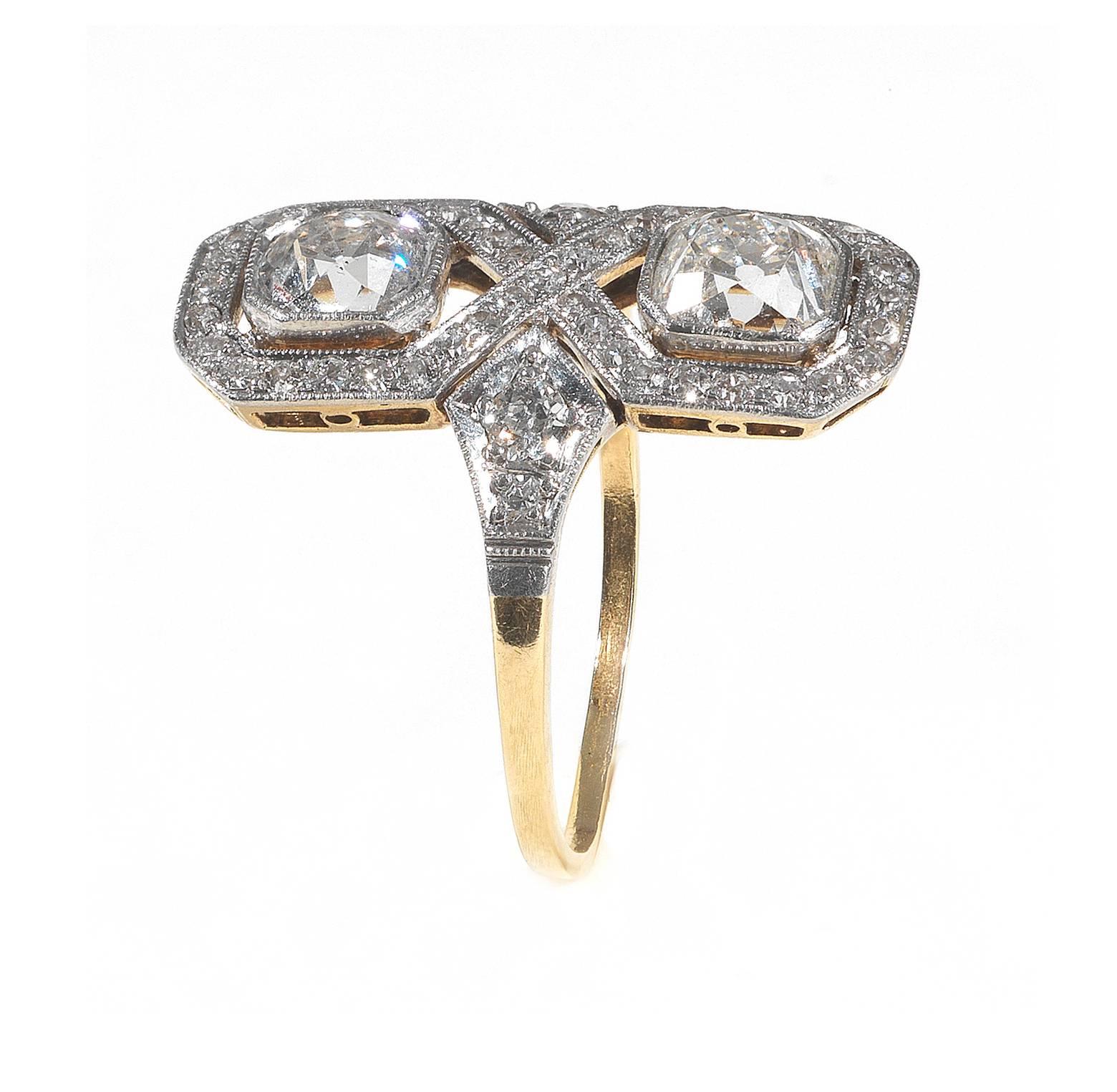 

Designed as stylized number 8 with two millegrain set cushion cut diamonds weighing approximately 2 cts, the borders and the shoulders set with round cut diamonds.

Mounted in platinum and yellow gold

Weight: 4.3 gr

Finger size: 8

