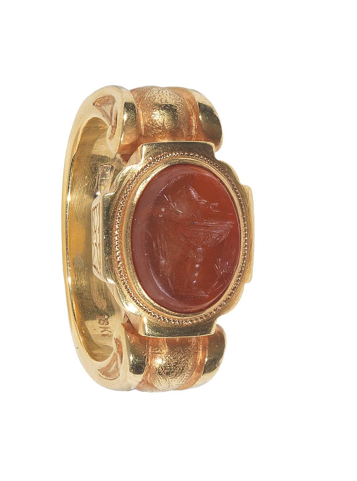 Der ovale Karneol stellt einen Vogel auf einer Tasse mit zwei Ähren an den Seiten dar

Karneol Größe: 10 x 8 mm

Montiert in 18Kt Gelbgold archäologischen Wiederbelebung Ring mit gravierten und Scrolls Seiten. 

Fingergröße: 7

Gewicht: 15.5