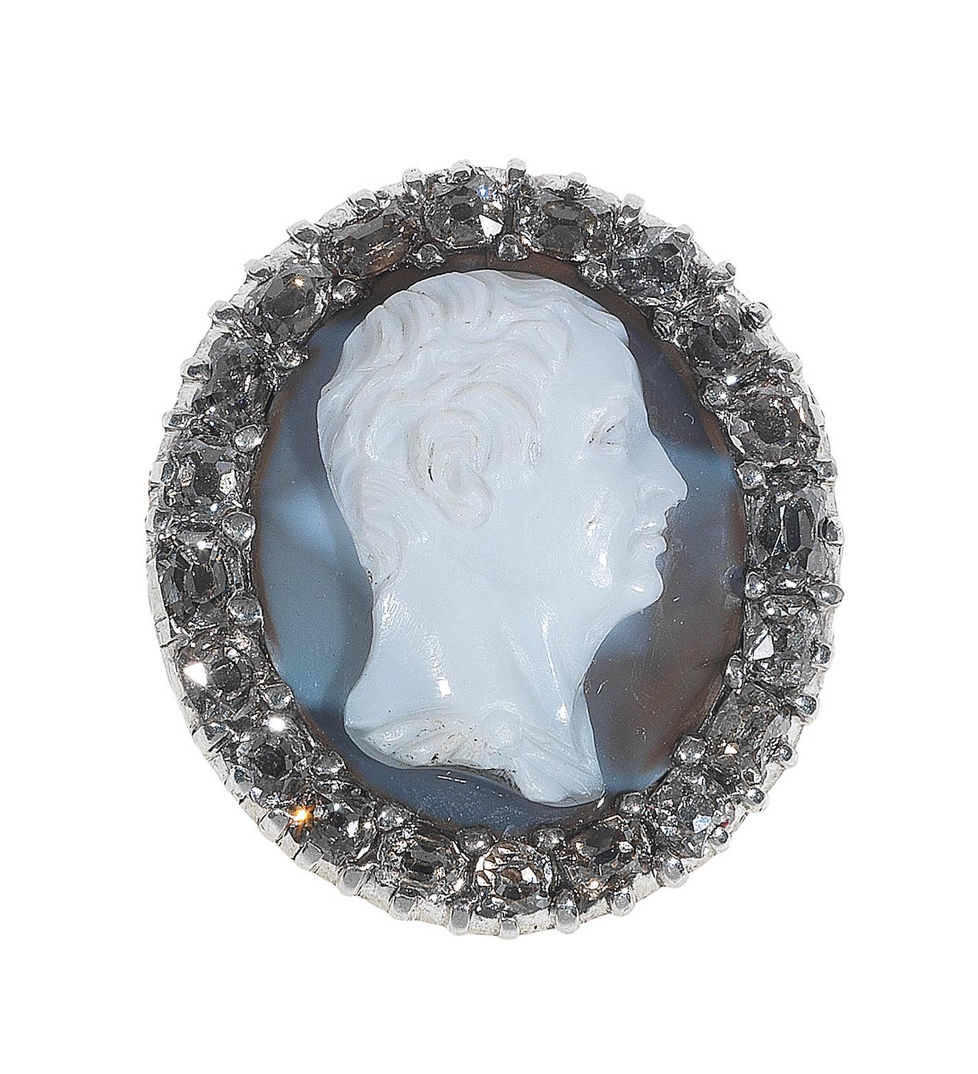 
The carved onyx cameo most probably depicting the profile of the Roman poet Gaio Valerio Catullo.

The oval bezel set with an onyx (white upper layer, translucent beige lower layer). The carving depicts a man in profile facing to the viewer’s