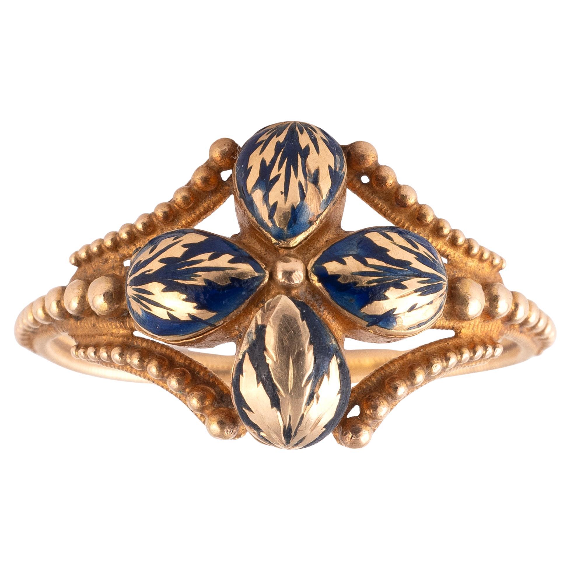 Anello con veleno in oro, la sezione centrale a forma di quadrifoglio è incernierata per rivelare quattro scomparti segreti con smalto blu.
Dimensione: 7
Peso: 5,9 grammi.

Un anello simile si trova nella Collezione Alice e Louis Koch, oggi Museo