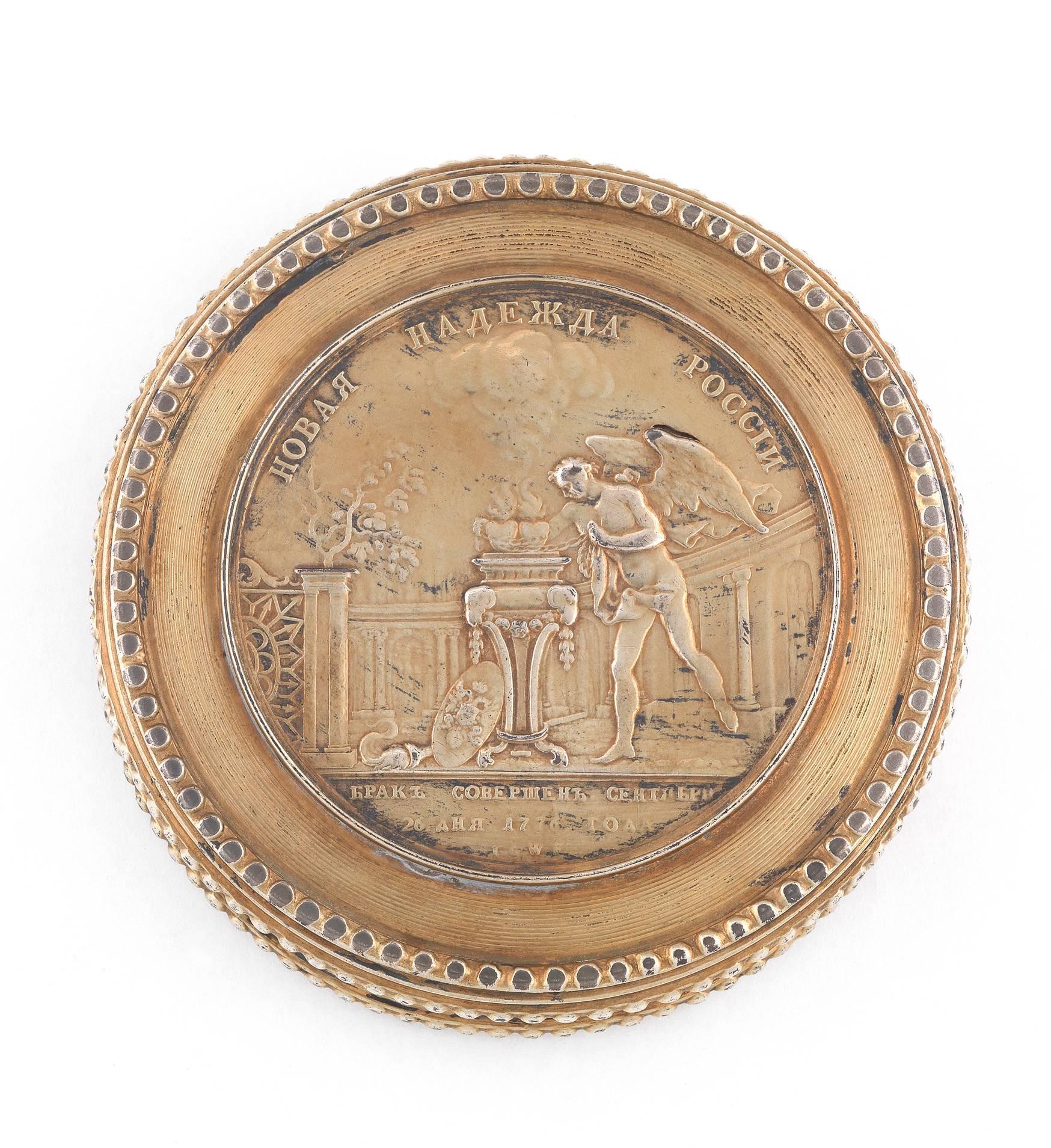 

Circular, the lid applied with a medal by Jaeger commemorating the 1776 marriage of Grand Duke Paul and Sophia Dorothea von Württemberg, the base decorated with a allegory of War and Art, husk borders
diameter: 8.5cm, 3 3/8 in

Grand Duke Paul,