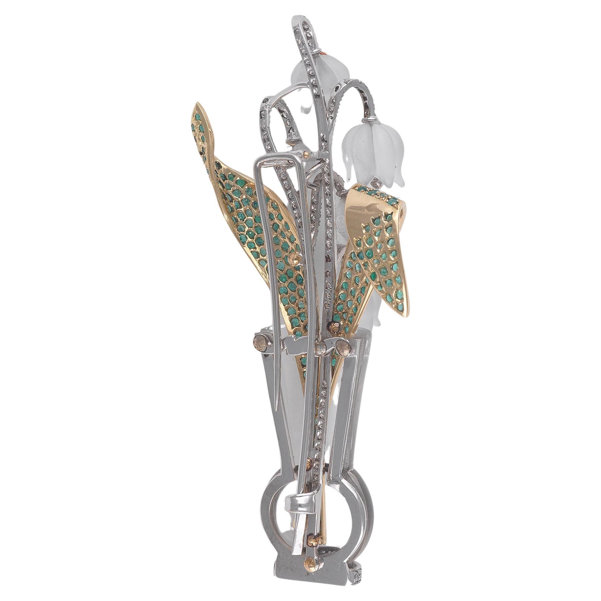 


Designed as a bouquet of pavé-set diamond lily of the valley flowers, accented by emerald leaves, to the rock crystal vase, mounted in 18k white gold, 8.4 cm long