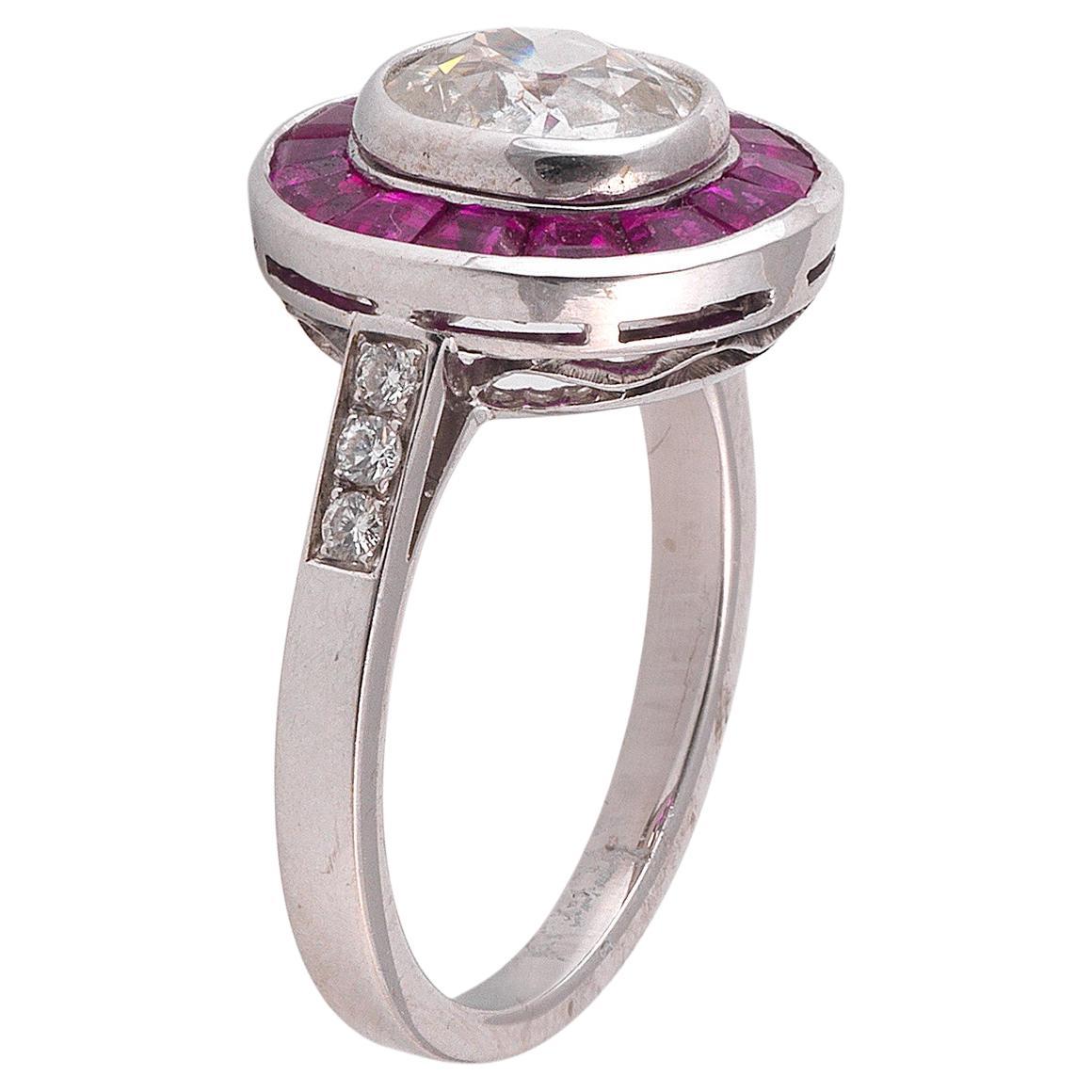 The central collet set old cut diamond weighing approx. 1.77 cts to a calibre-cut ruby surround, plain hoop, mounted in white gold.

Weight: 5.7 gr

Finger size: 7