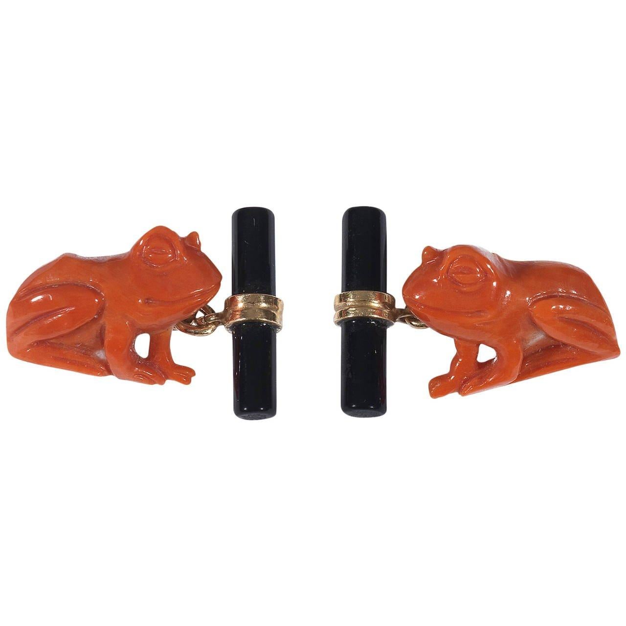 
Pair of cufflinks designed as carved coral frog.

Chain link connections with onyx baton.   

Mounted in 18Kt yellow gold