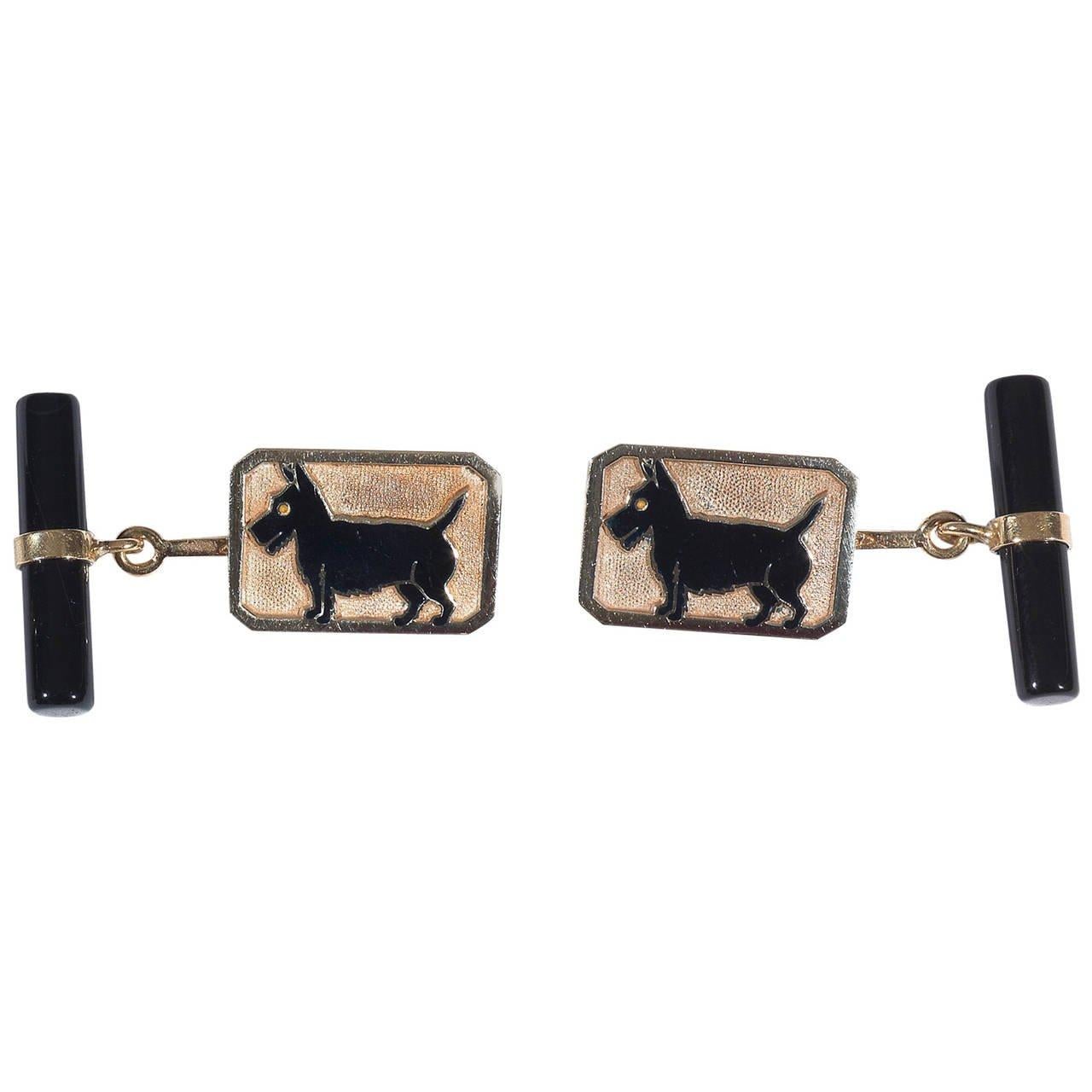 
The rectangular plaques depicting two black enamel Scottish Terrier

Chain link connections with onyx baton.   

Mounted in 18Kt yellow gold