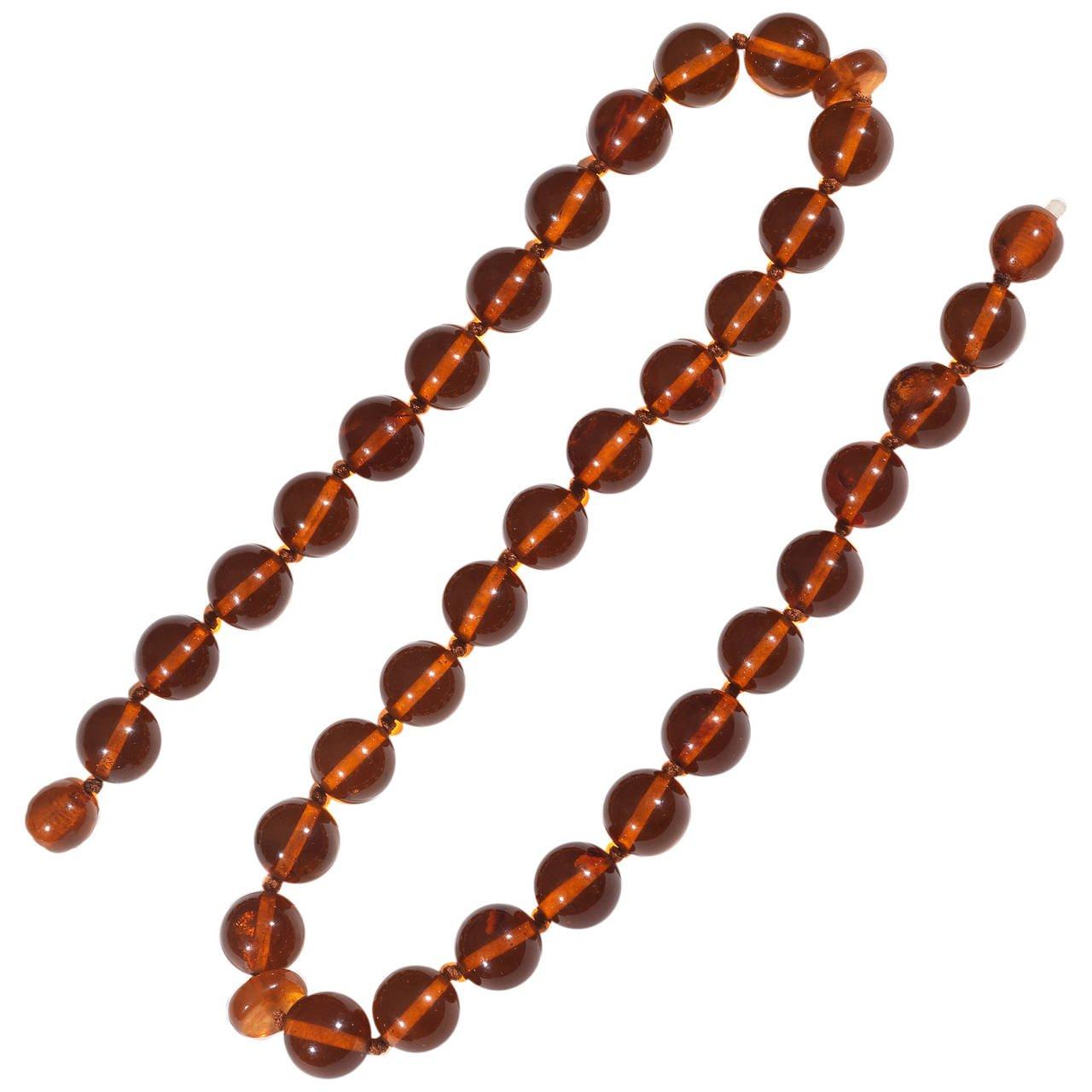 The single-strand of round amber beads approx. 14 mm diameter
Two beads with internal screw locking.

Length 56 cm.

Total weight: 51.7 gr