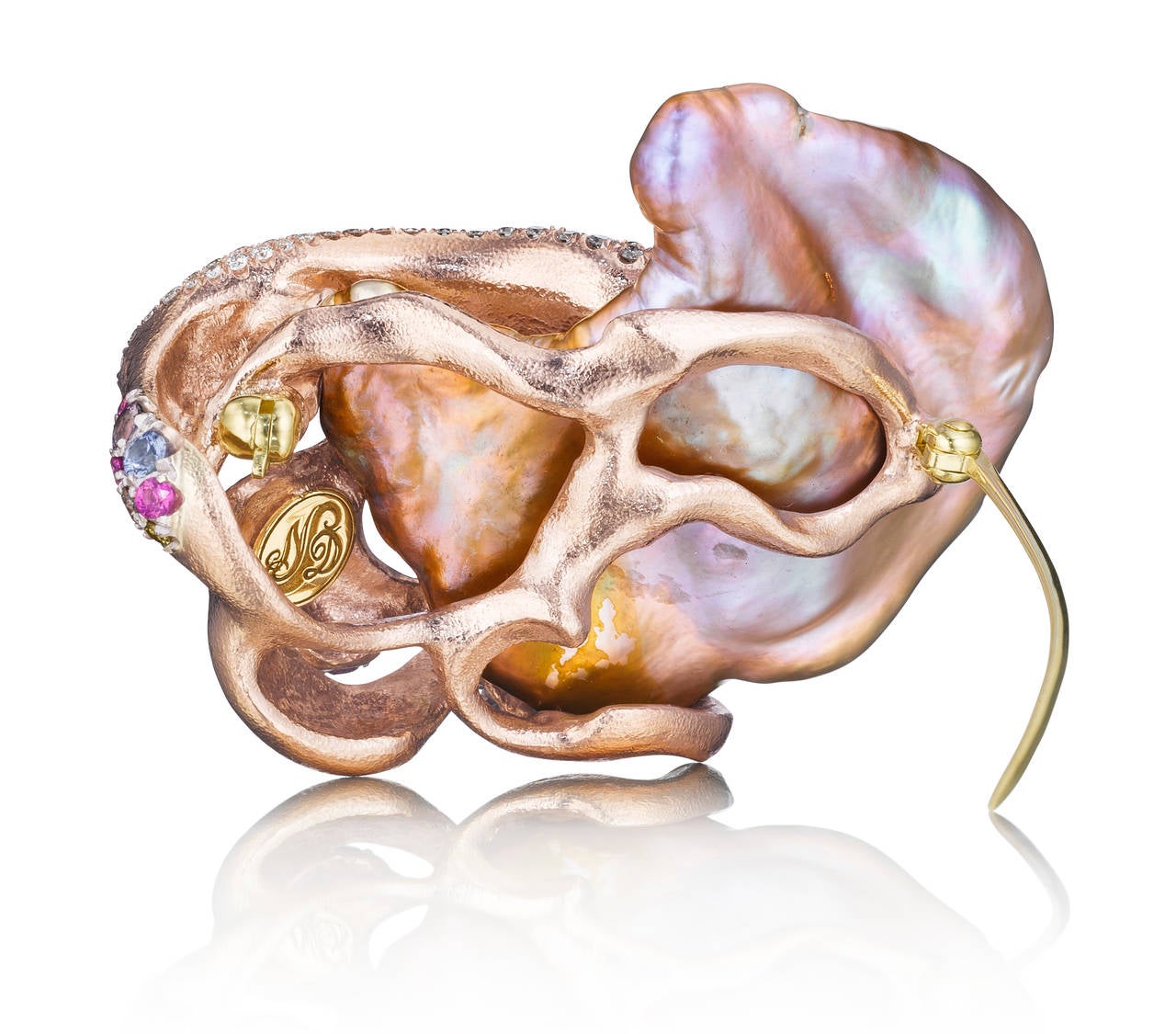 A completely original, award winning, extraordinary design featuring a Chinese freshwater pearl in purples, pinks, and golds. It is surrounded by a wave of 18K peach gold and platinum set with multicolored diamonds, sapphires, and amethysts which