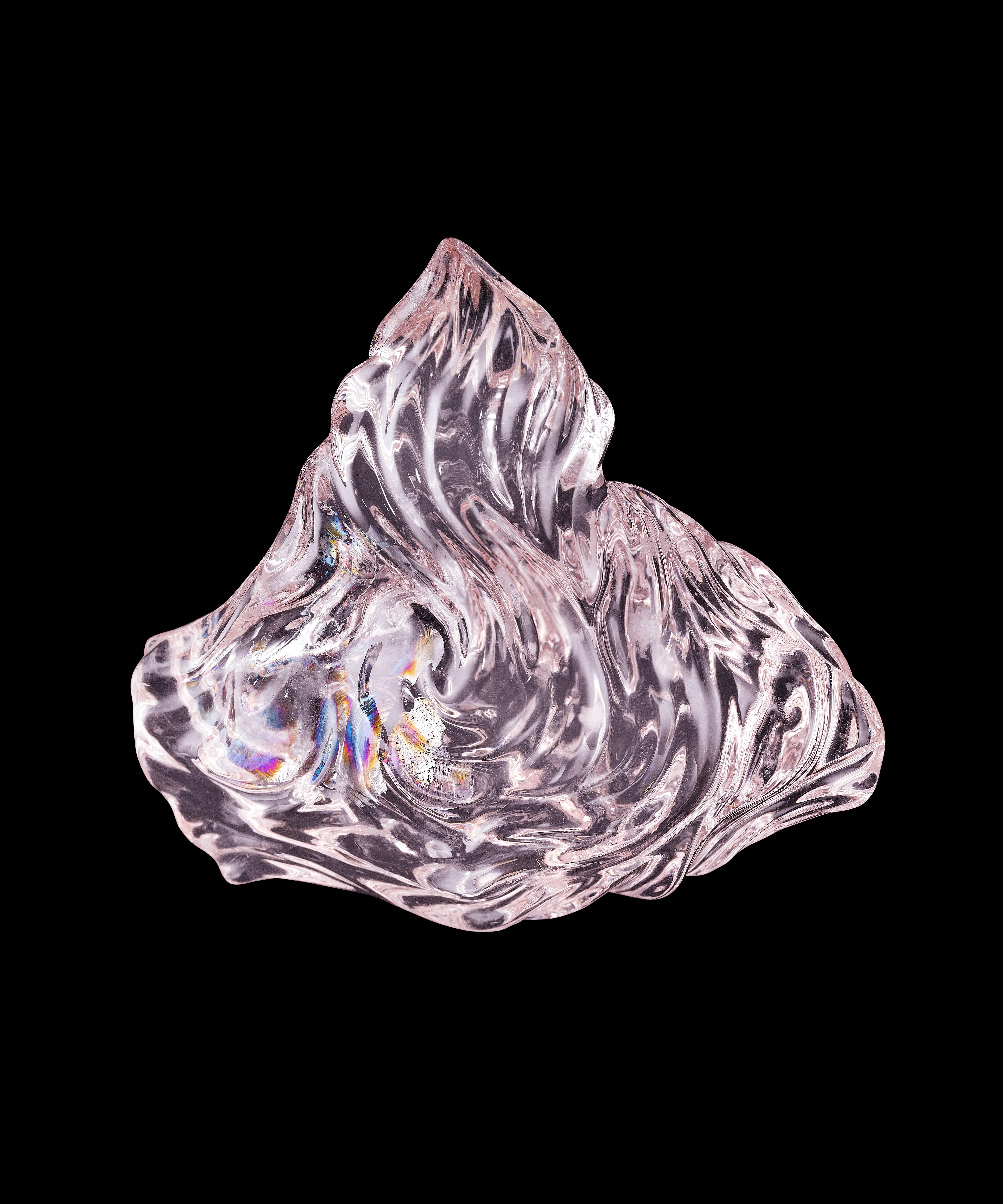 This sensuous carving enhances internal rainbow fractures which are self-healed and snowflake shaped inclusions. It's like holding a rainbow in your hand. It is 942 ct (197 g) and stands on a sterling silver base. Like all of Naomi's carvings, this