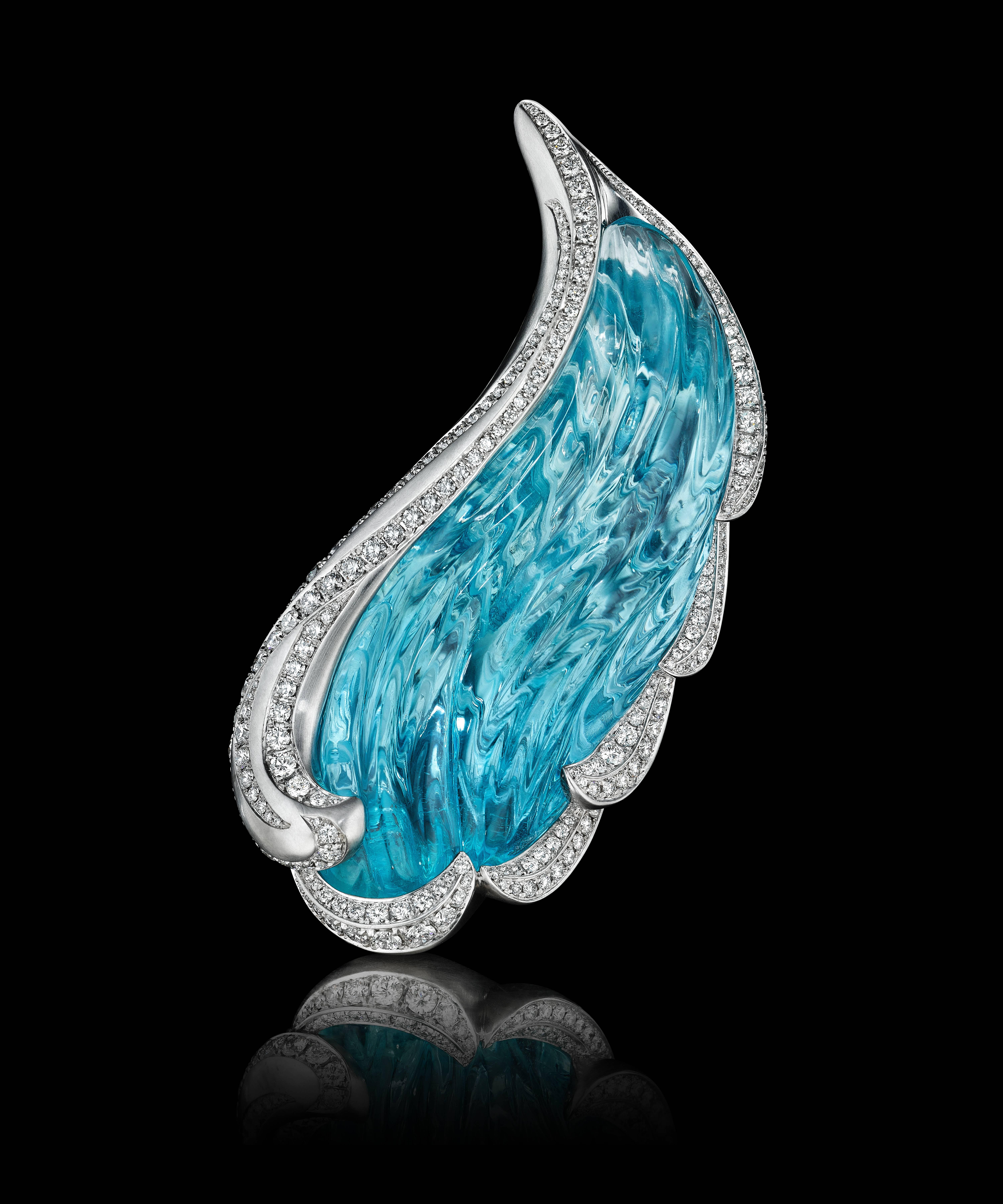 Stunning, one of a kind brooch featuring a hand-carved natural, unheated 91.64 ct aquamarine. The gem is carved masterfully on both sides to create an intricate play of light and color. Set in custom crafted 18K palladium white gold with flowing