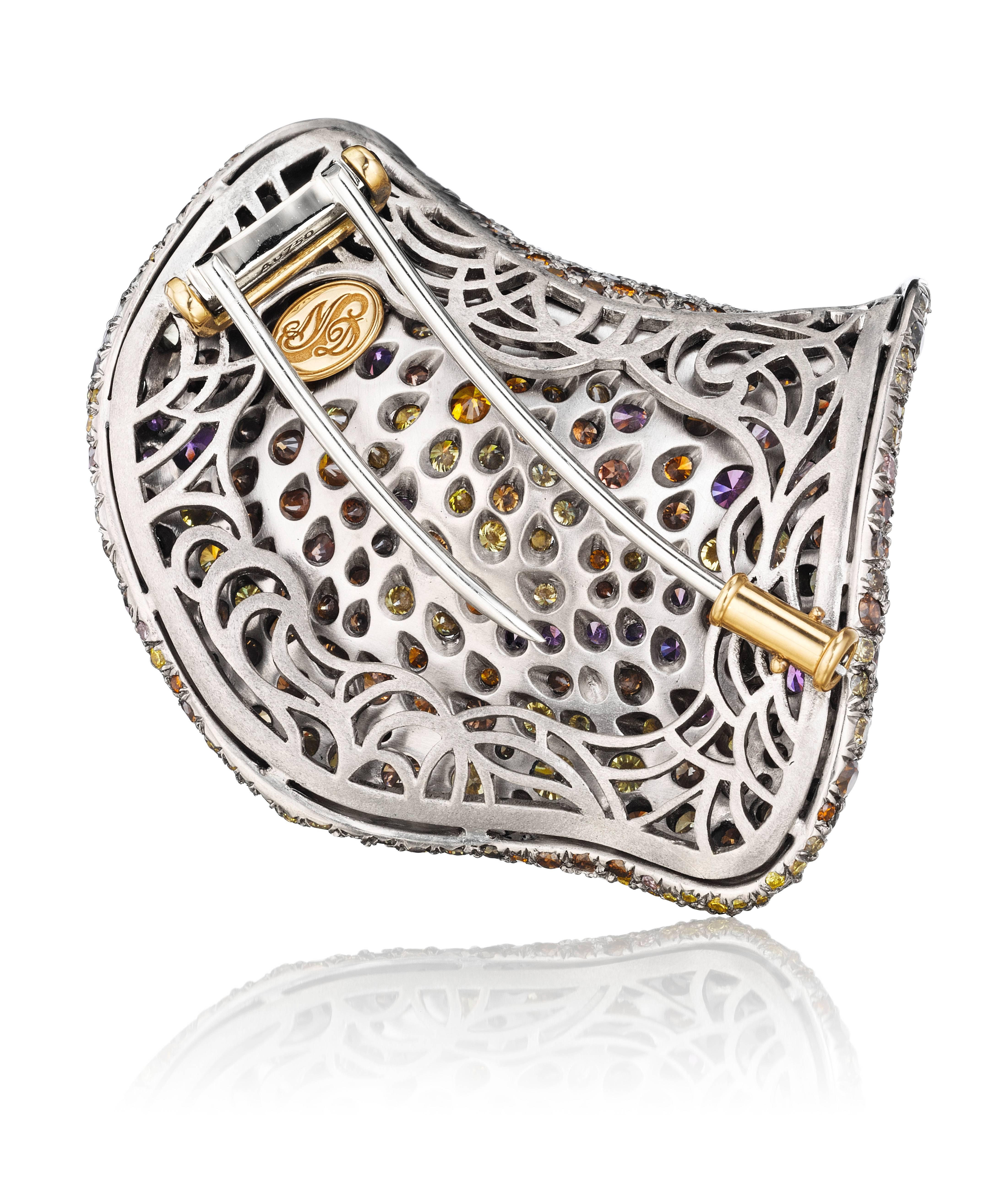 A mysterious petal brooch that glows and comes to life in subdued light. 18K white gold set with approximately 675 stones consisting of mainly olive, yellow, fancy orangey-brown, pink, and white diamonds which are complimented by multicolored