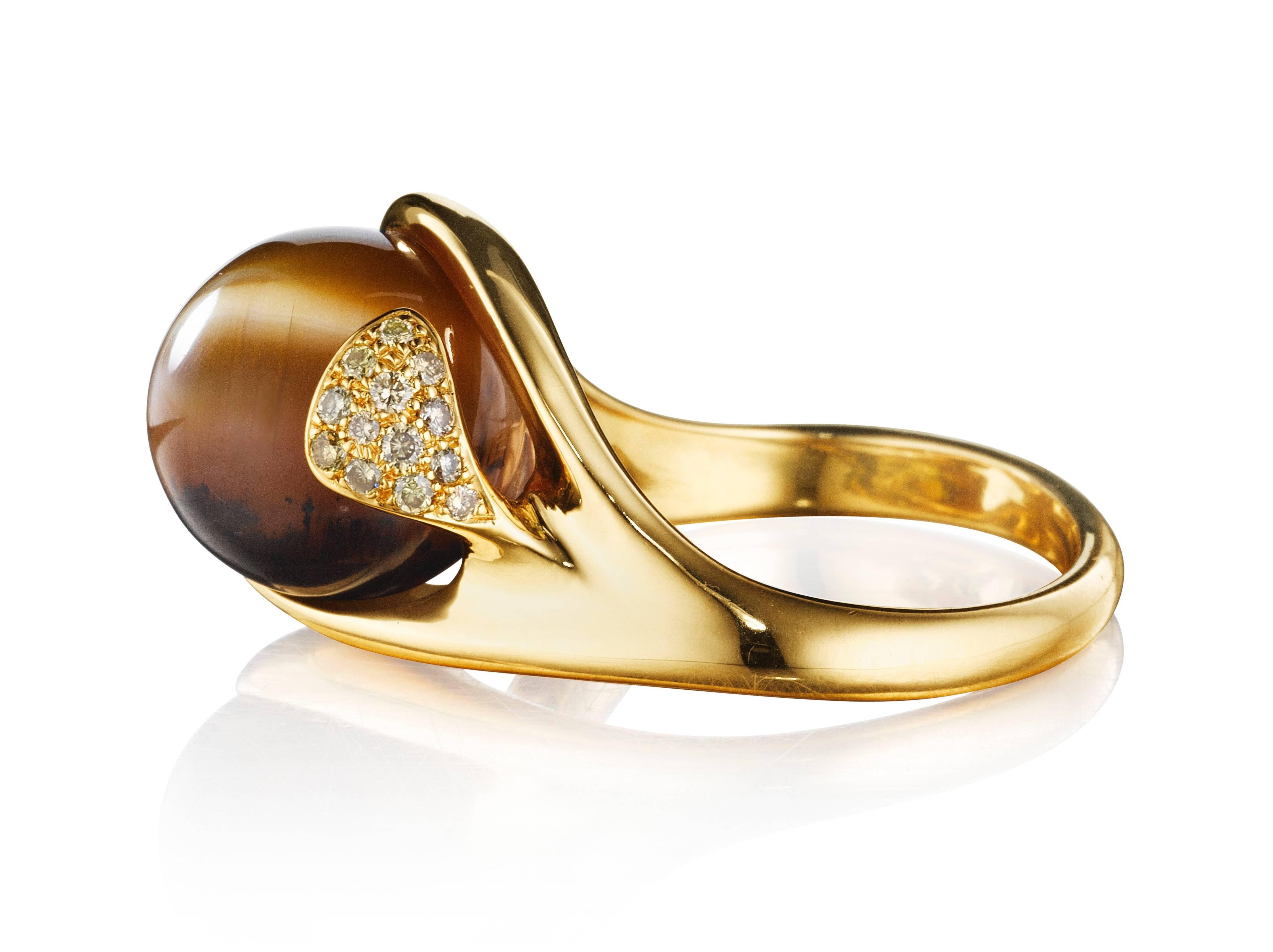 This hand-crafted ring features a brown cat's eye opal set in 18K yellow gold and complimented by VS-FG white diamonds . Like all rings from Naomi Sarna, this is an extremely comfortable ring to wear. 

Internationally award winning designer Naomi