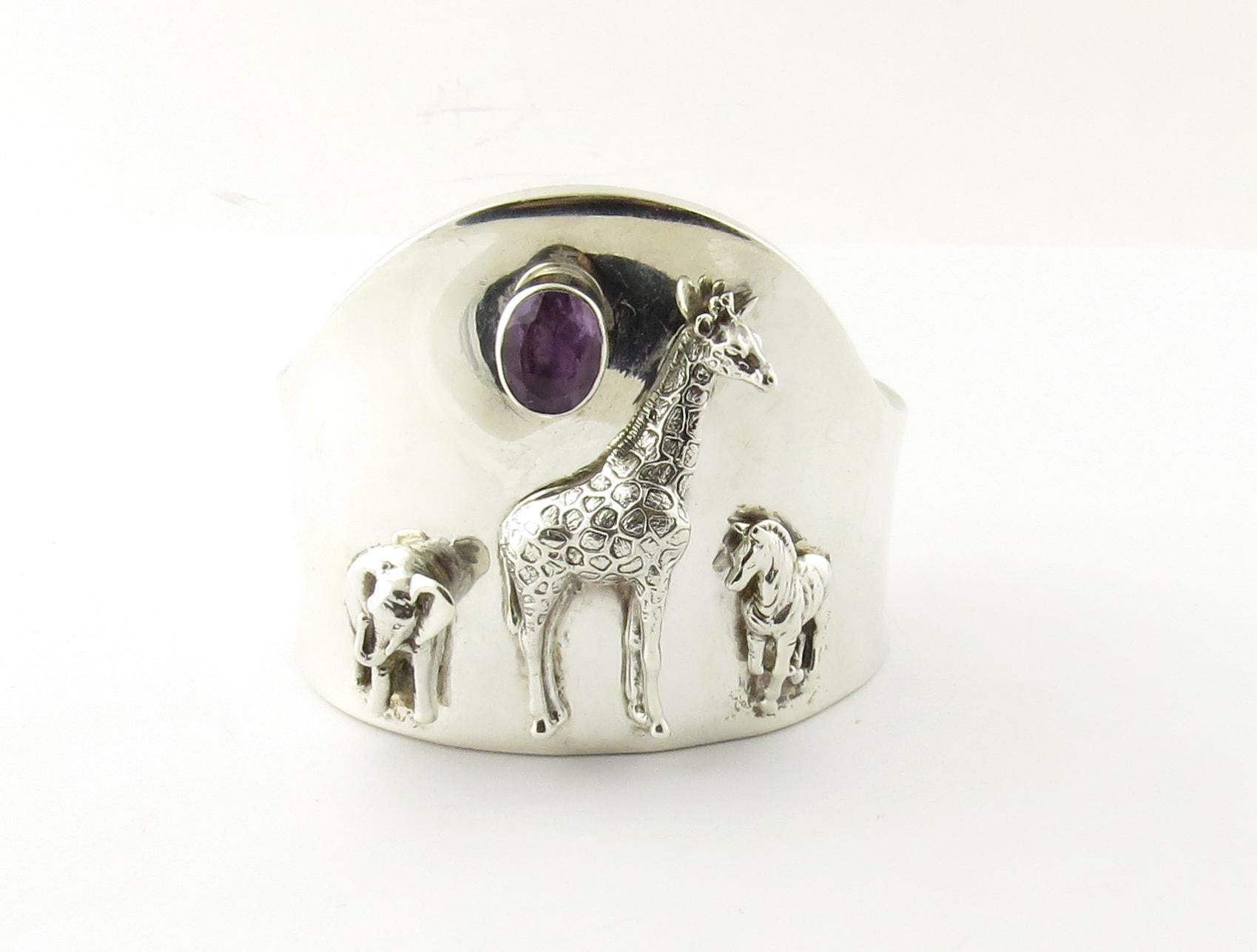 Carol Felley Southwestern Sterling Silver Wildlife Amethyst Cuff Bracelet 1997
This beautiful cuff bracelet is designed with a Elephant, Giraffe and Mustang Horse
An oval bezel set amethyst approx. 12mm x 10mm also adorns the front of the