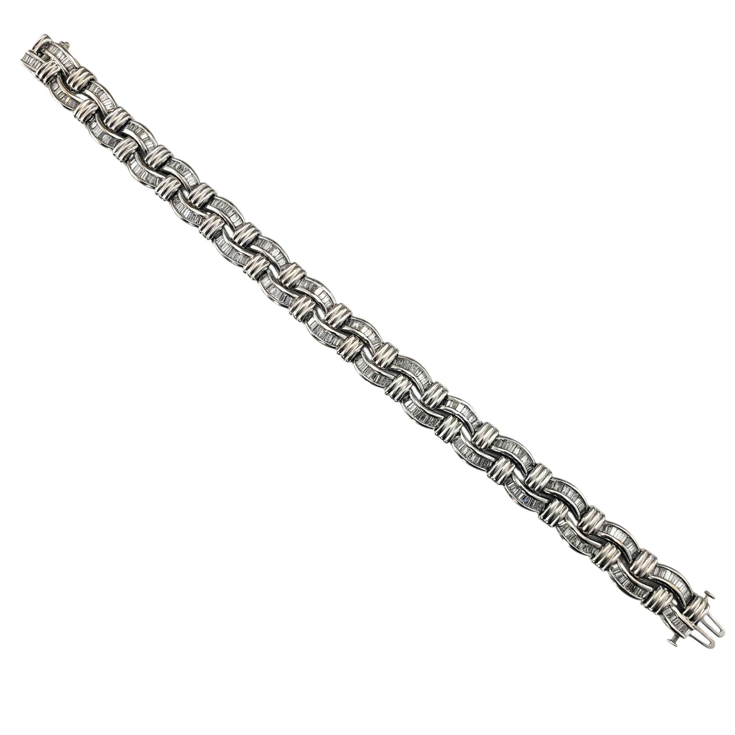 Pulsera de diamantes baguette de oro blanco de 14 quilates con certificado JAGi-

Esta elegante pulsera de oro blanco de 14 quilates presenta un sofisticado diseño trenzado engastado con 254 diamantes talla baguette en un engaste de canal sin juntas