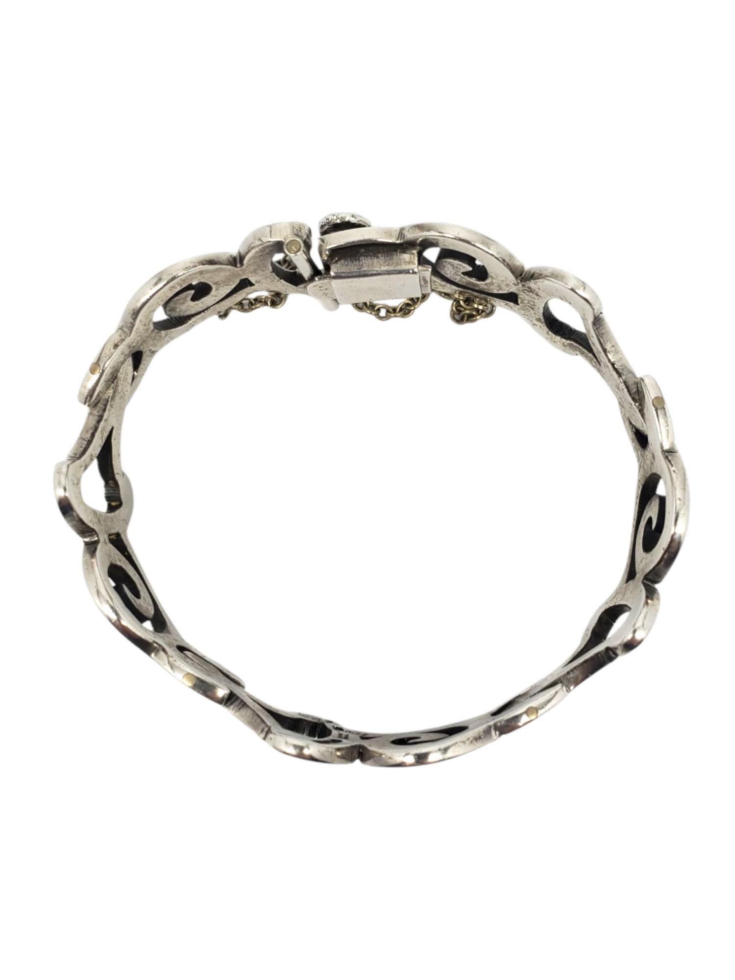 Bracciale a spirale in argento sterling Taxco Mexico-

Questo elegante braccialetto in argento sterling proveniente da Taxco Mexico presenta un intricato disegno a volute aperte splendidamente realizzato a mano con una chiusura sicura e una catena