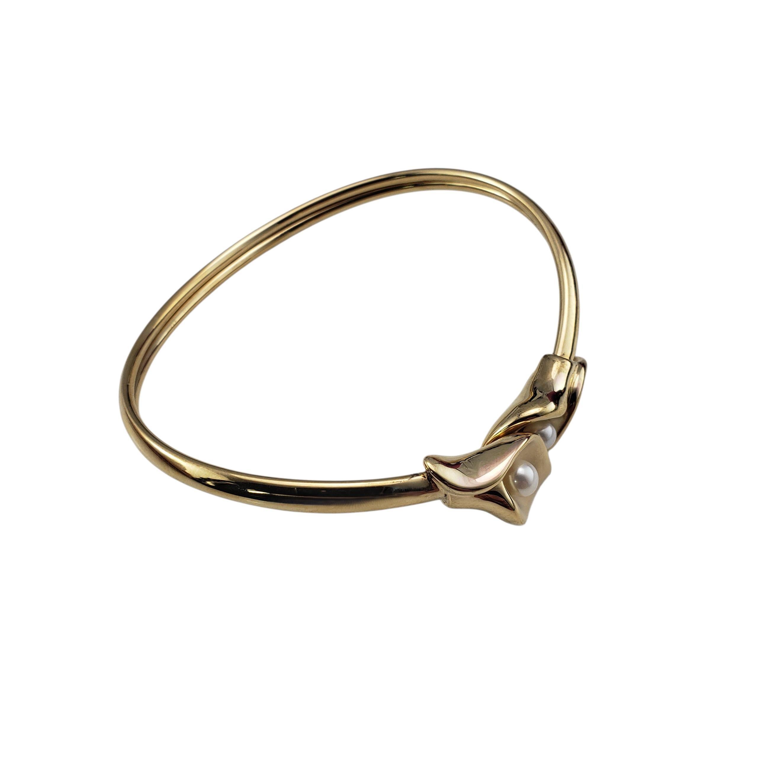Bracciale con giglio della calla in oro giallo 14 carati e perle...

Elegante e scultoreo, questo braccialetto bangle in oro giallo 14K presenta un motivo a calla splendidamente lavorato al centro, accentuato da due perle luminose (5 mm ciascuna).