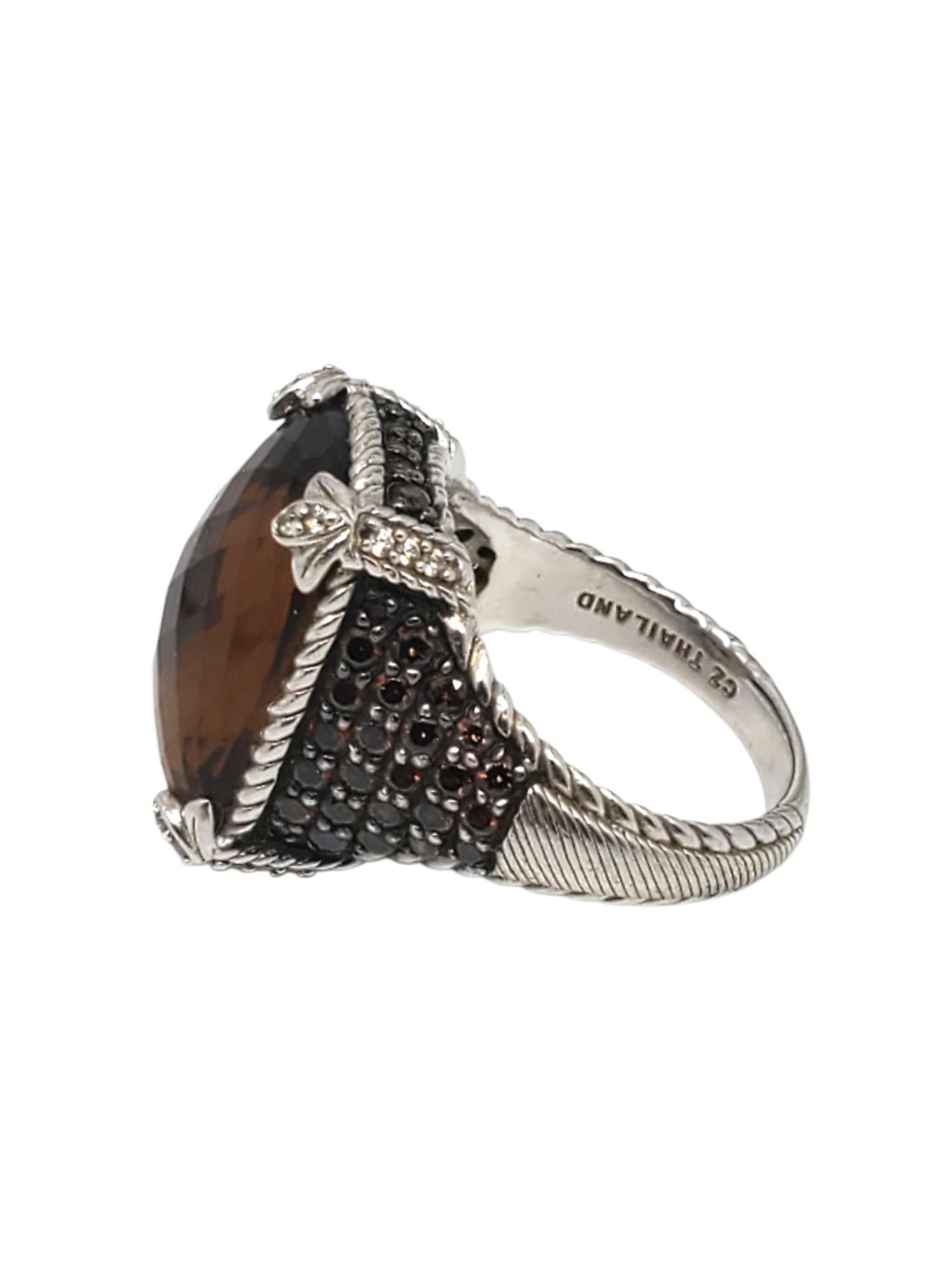 Anello Judith Ripka in argento sterling con pietra marrone -

Questo bellissimo anello di Judith Ripka presenta un quarzo marrone sfaccettato (20,34 mm x 15,05 mm) al centro e pietre laterali di quarzo e CZ incastonate in un design a corda in