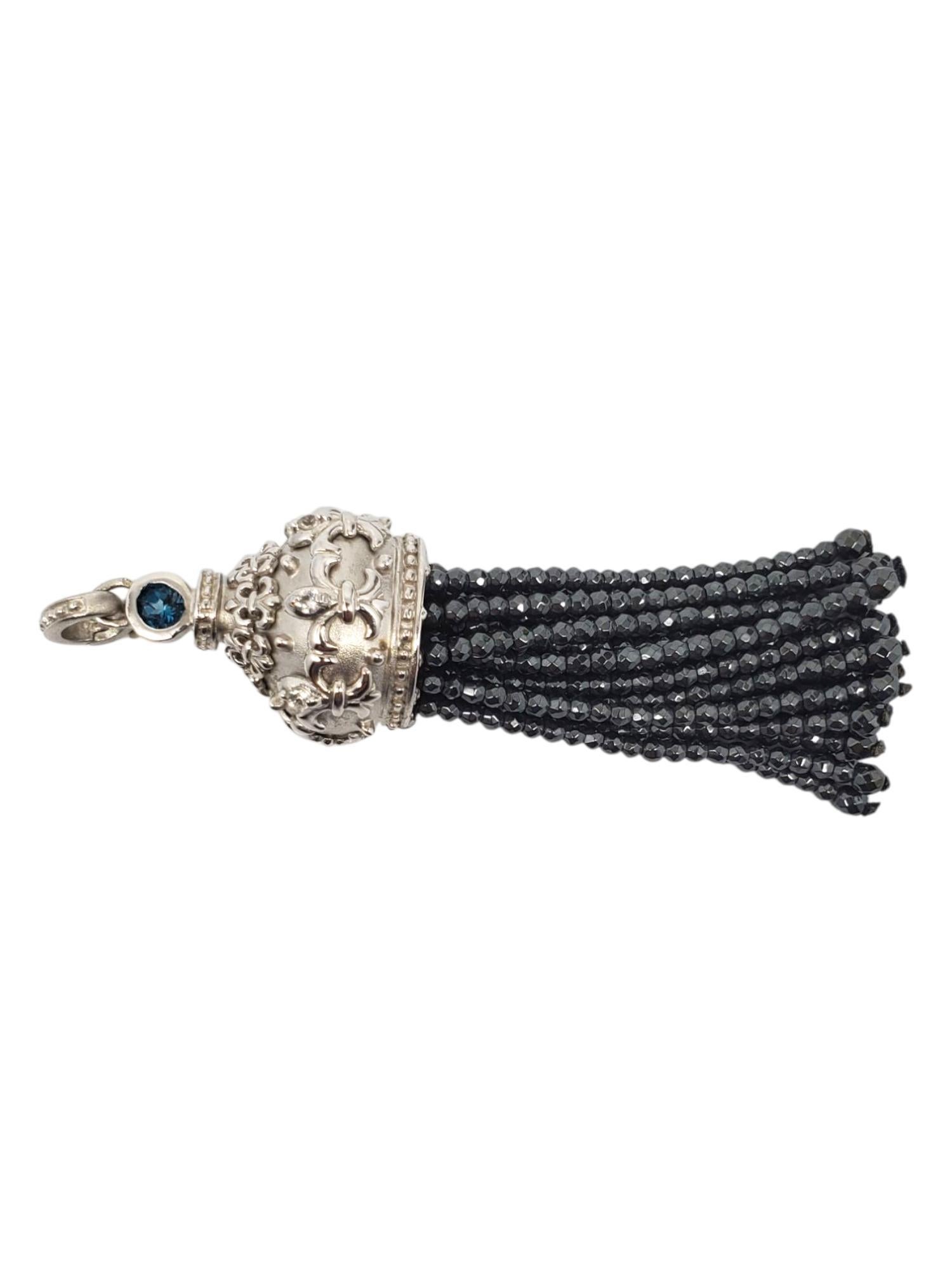 Ciondolo a forma di nappina in argento sterling con pietra blu sfaccettata 

Questo ciondolo vintage presenta una pietra blu sfaccettata (3 mm x 3,2 mm) incastonata in un cappuccio in argento sterling ornato con accenti CZ e una frangia di perline