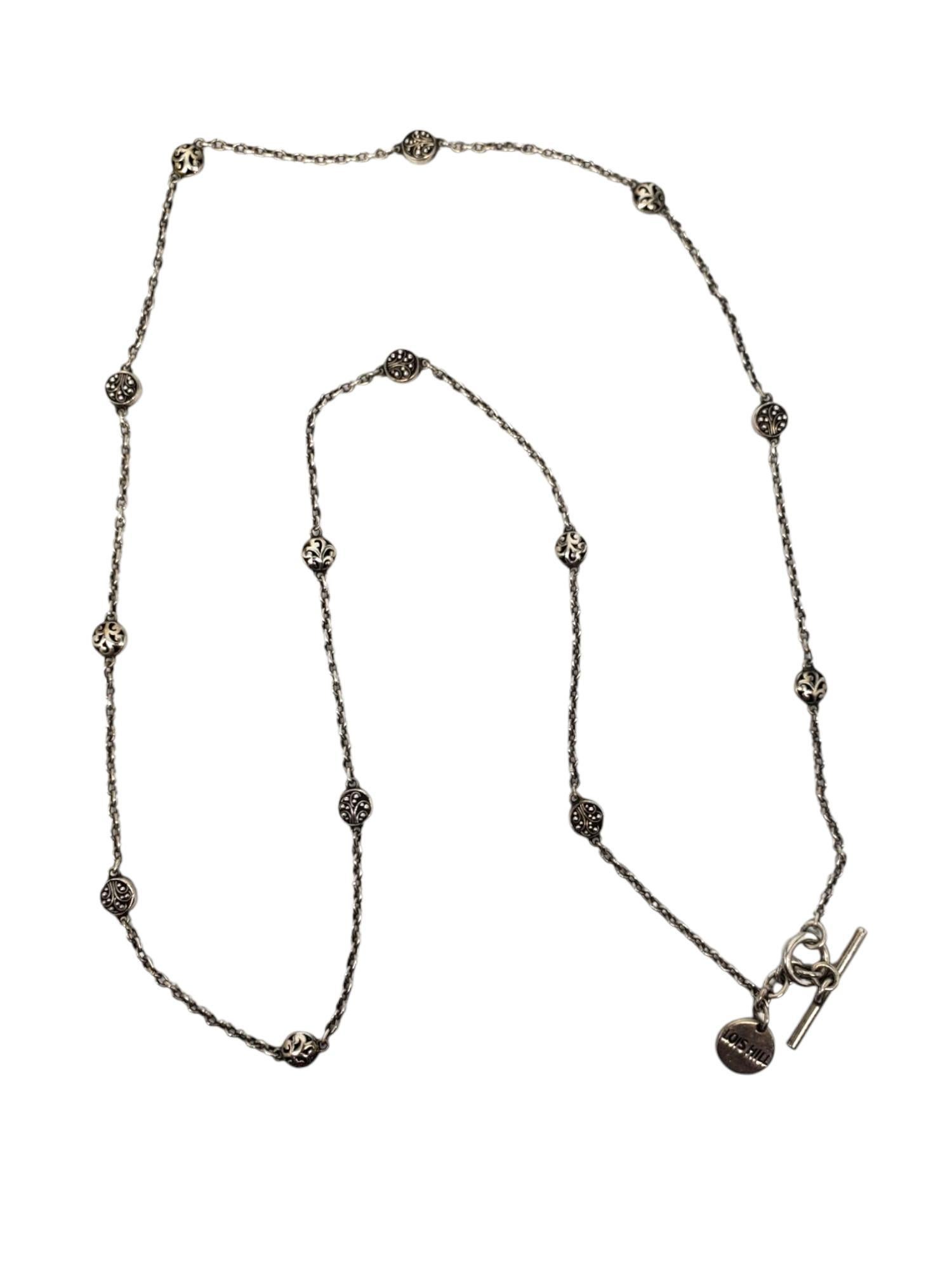 Lois Hill - Collana in argento filigranato a stazioni -

Questa delicata collana a stazioni è caratterizzata da un'alternanza di dischi a voluta e perline in filigrana distanziati da una catena a maglie da 29 pollici con chiusura ad