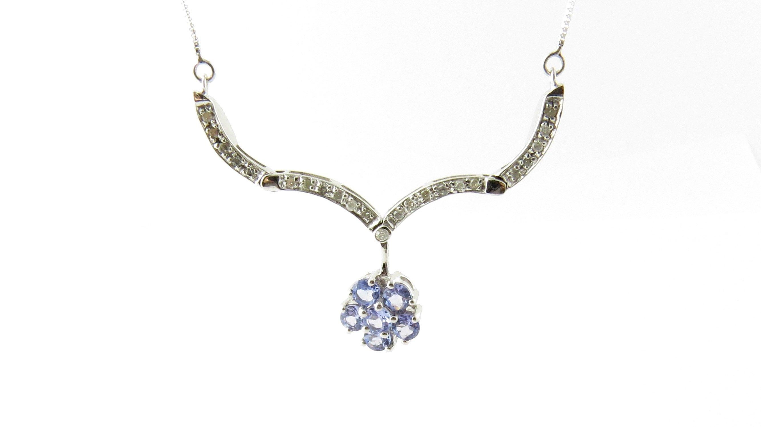 Vintage 10 Karat White Gold Genuine Tanzanite and Diamond Pendant Necklace. This lovely pendant features six round genuine tanzanite gemstones (4 mm each) surrounded by 22 round single cut diamonds suspended from a classic white gold