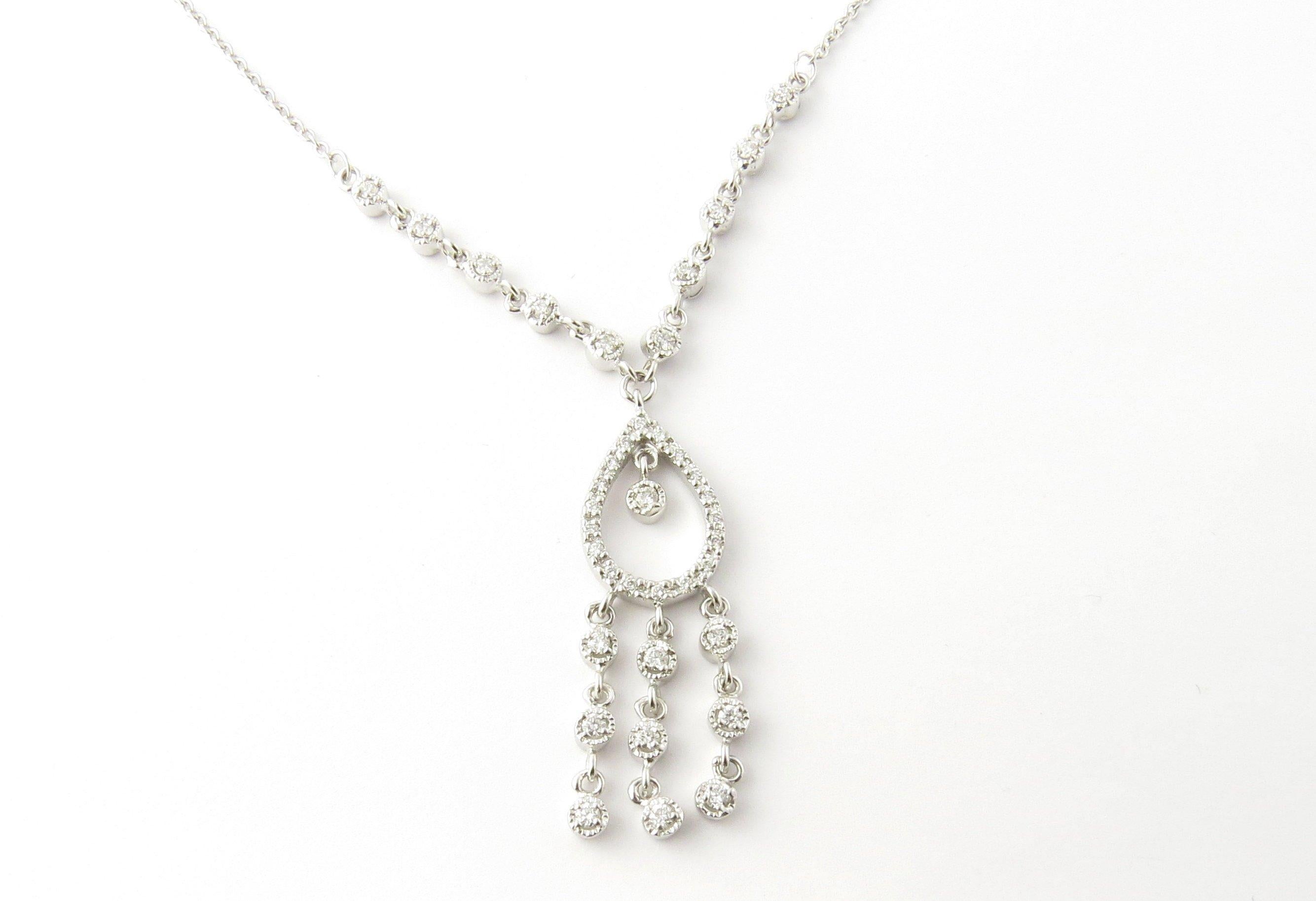 Vintage 14 Karat White Gold Diamond Pendant Necklace. This dazzling dangling pendant features 38 round brilliant cut diamonds (28 in pendant, 10 on necklace) set in beautifully detailed 14K white gold.
Approximate total diamond weight: .79 ct.