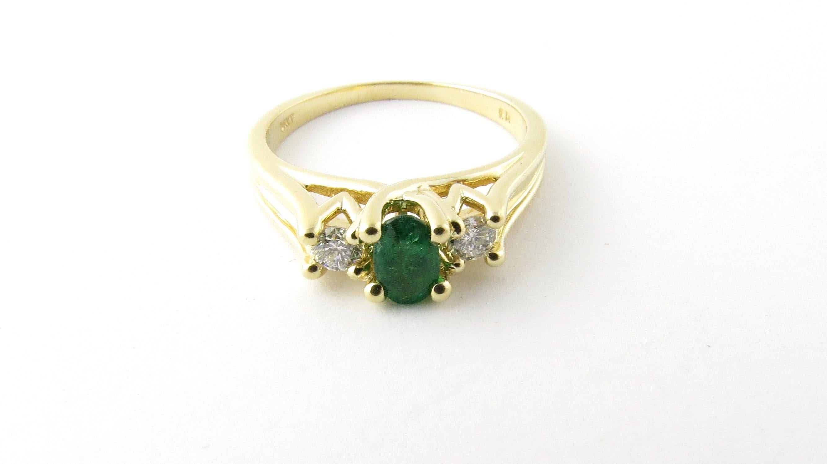 Vintage 14 Karat Yellow Gold Genuine Emerald and Diamond Ring Size 7.25. This lovely ring features one oval genuine emerald (6 mm x 4 mm) accented with two round brilliant cut diamonds set in classic 14K yellow gold. Shank measures 1.5