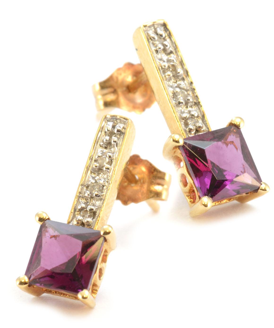 Excellent condition. These solid 14k yellow gold earrings feature a square genuine garnet in each earring. These garnets measure about 5.20mm X 5.20mm. Each earring also features 4 genuine diamonds. The earrings measure approximately 15mm X 5.20mm.