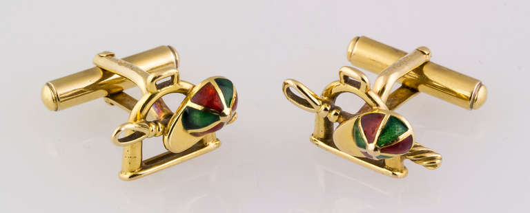 Handsome 18K yellow gold and enamel cufflinks by Gucci, circa 1970s. They feature an equestrian motif: a jockey hat, a whip, and a stirrup. 
Hallmarks: Gucci, 750, Italy, maker's mark.