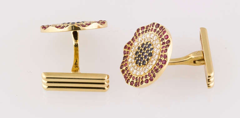 Very handsome set of  sapphire, ruby, diamond and 18K yellow gold cufflinks by Cartier, circa 1989. They feature very high grade round brilliant cut stones, with sapphires in the center, with two rows of diamonds, and two rows of rich red rubies on