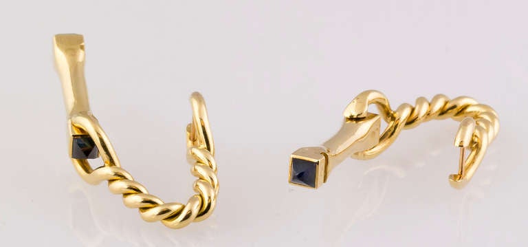 Handsome estate sapphire and 18K yellow gold cufflinks by Cartier, circa 1940s-50s. They feature a twisted rope design with rich blue sapphires on each end. 
Hallmarks: Cartier, reference numbers, French 18K gold assay marks, maker's mark.