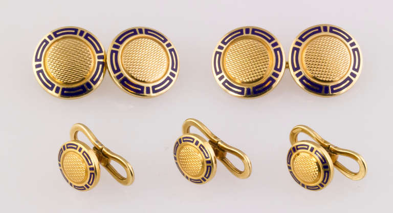 Handsome 18K yellow gold and blue enamel cufflink and 3 stud set by Bulgari. It features an engine turned design, with blue enamel accents around the edges. Comes with three studs. 
Hallmarks: Bulgari, 750, reference numbers.