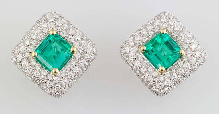 Vibrant Colombian emerald, diamond and 18K white gold earclips by Cellini. Designed with a diamond shape, they feature very high grade round brilliant cut diamonds, weighing 3.97cts total weight. The two emerald cut emeralds are of fine color and
