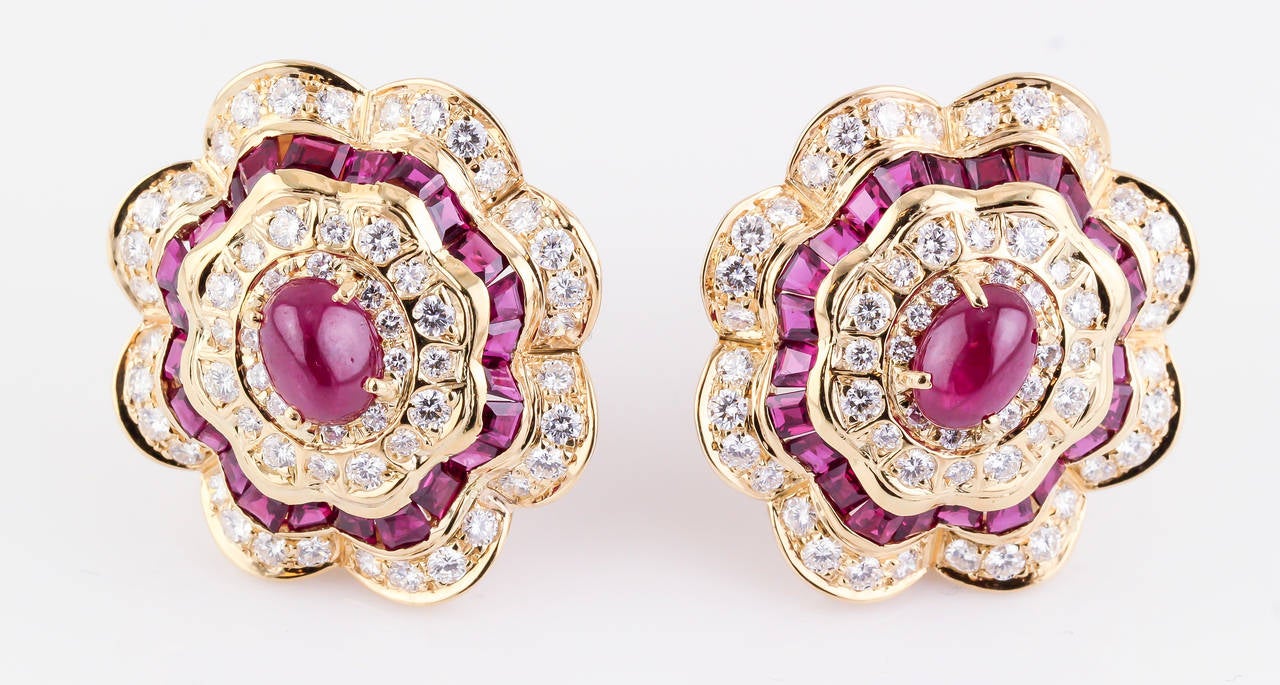 Impressive ruby, diamond and 18K yellow gold ear clips. They feature high grade round brilliant cut diamonds, of approx. 4- 4.5 carats total weight. Also fseature rich red cabochon ruby center stones, along with a ring of square cut rubies, all very