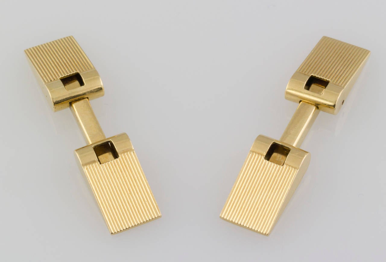 Handsome 18K yellow gold, ribbed folding cufflinks of French origin, circa 1950s-60s. They feature a spring loaded folding mechanism for ease of installation.

Hallmarks: maker's mark, French 18K  import mark (owl), BTE.