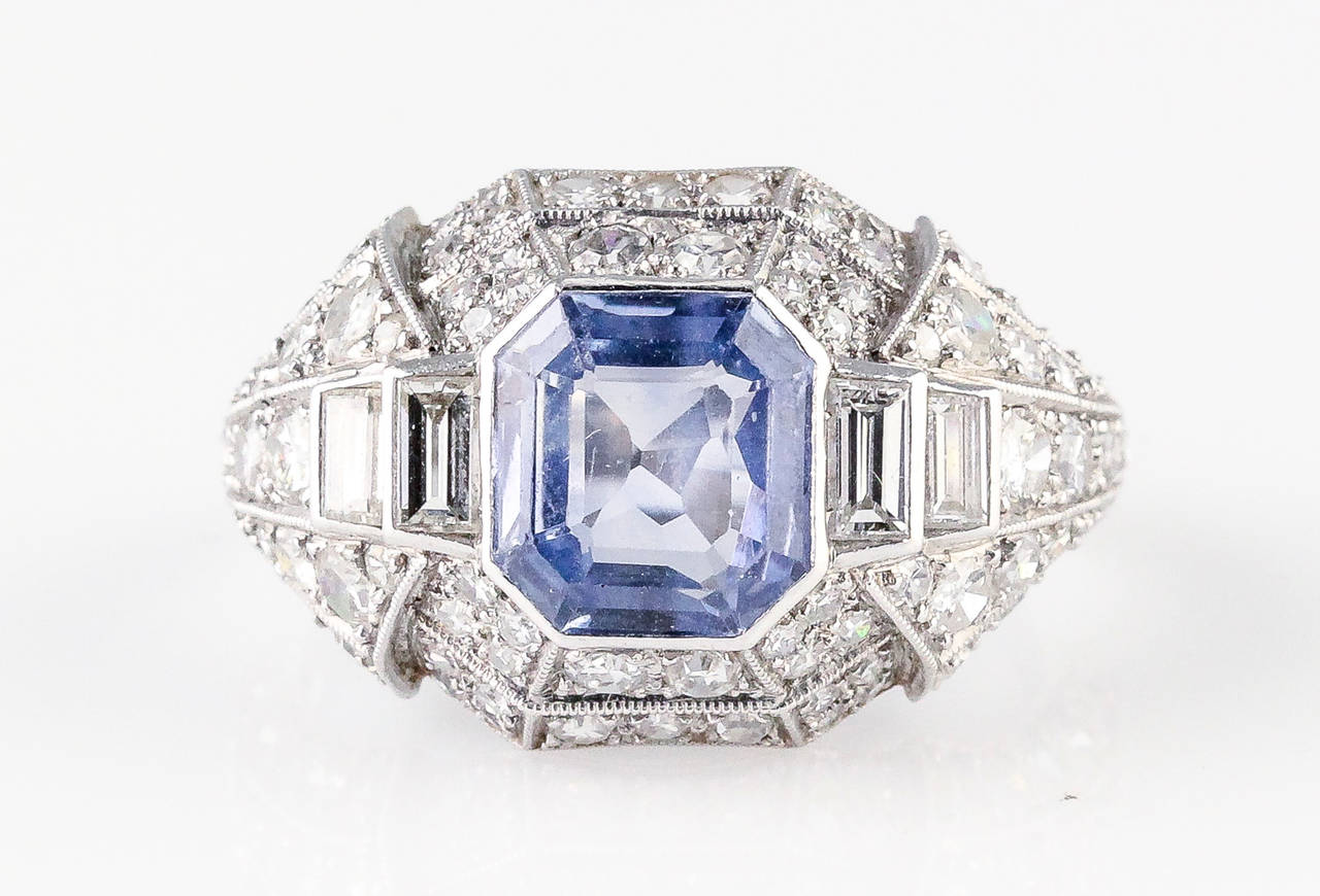 Elegant blue sapphire, diamond and platinum ring, circa 1920s. It features a large blue sapphire in the middle, with high grade round and emerald cut diamonds around it.