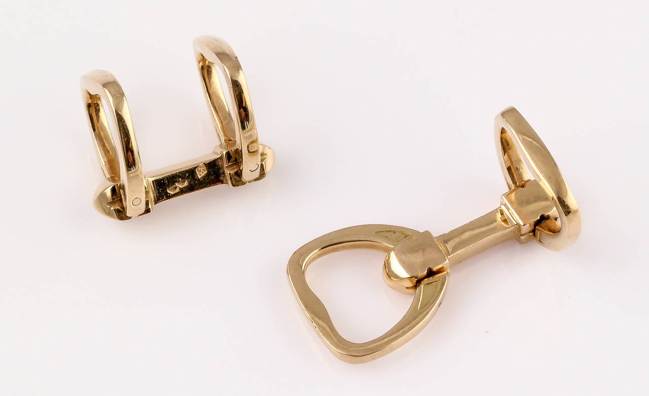 Magnifiques boutons de manchette en or jaune 18 carats par Hermès:: vers les années 1970. Ils ressemblent à des étriers et possèdent un mécanisme de pliage intéressant qui maintient la manchette en place. 

Des poinçons : Hermès:: marque du